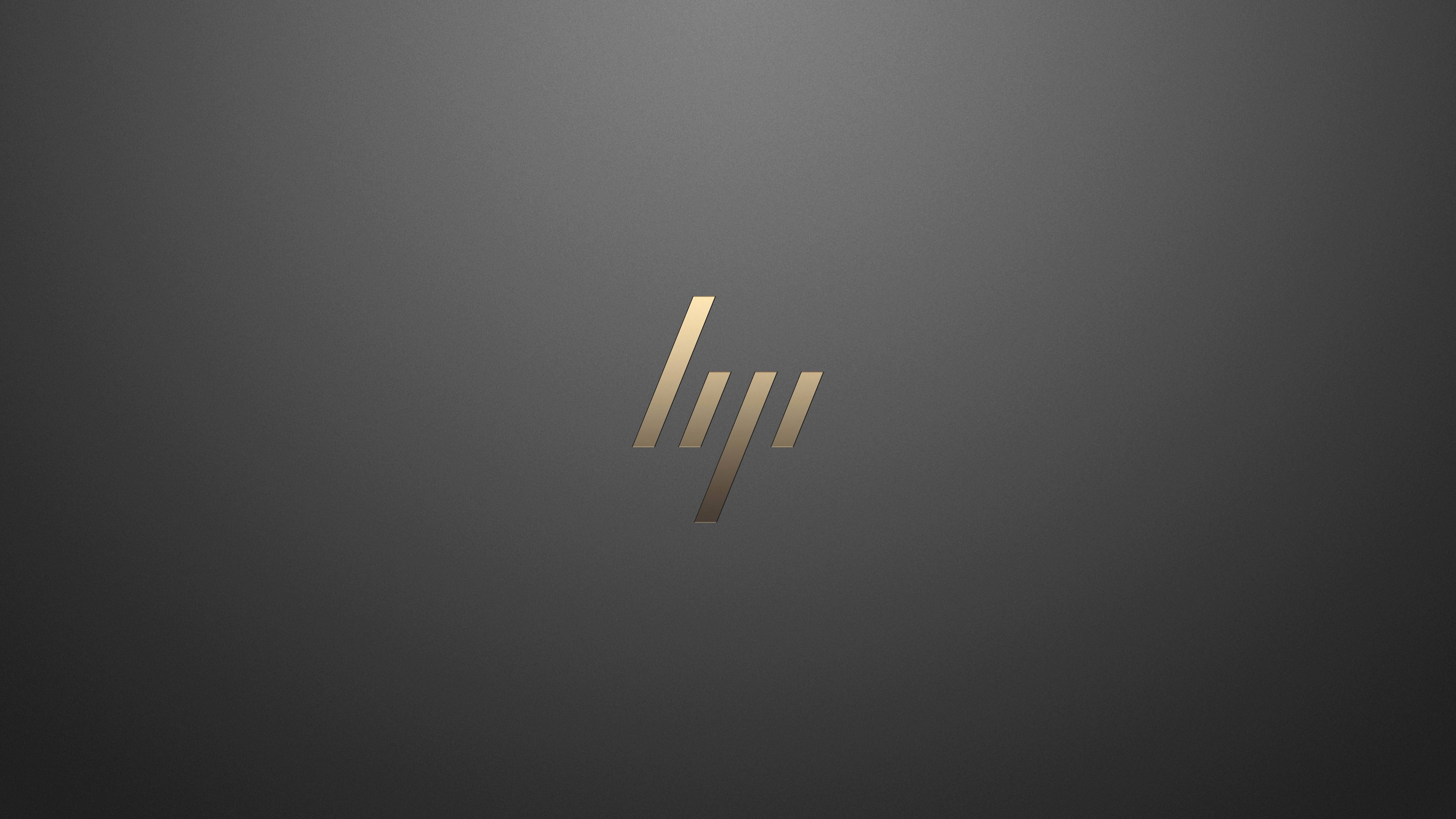 HP 桌布 壁紙 — 一個時尚的金色HP標誌，居中於漸變灰色背景上，帶有柔和燈光。