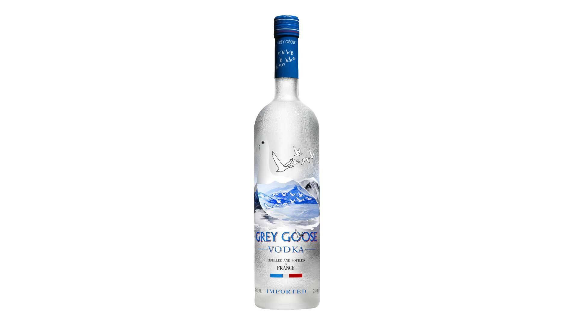 alcohol 桌布 壁紙 — 一個時尚的銀色 Grey Goose 伏特加酒瓶，帶有藍色瓶蓋和山鵝插圖，背景為純白色。