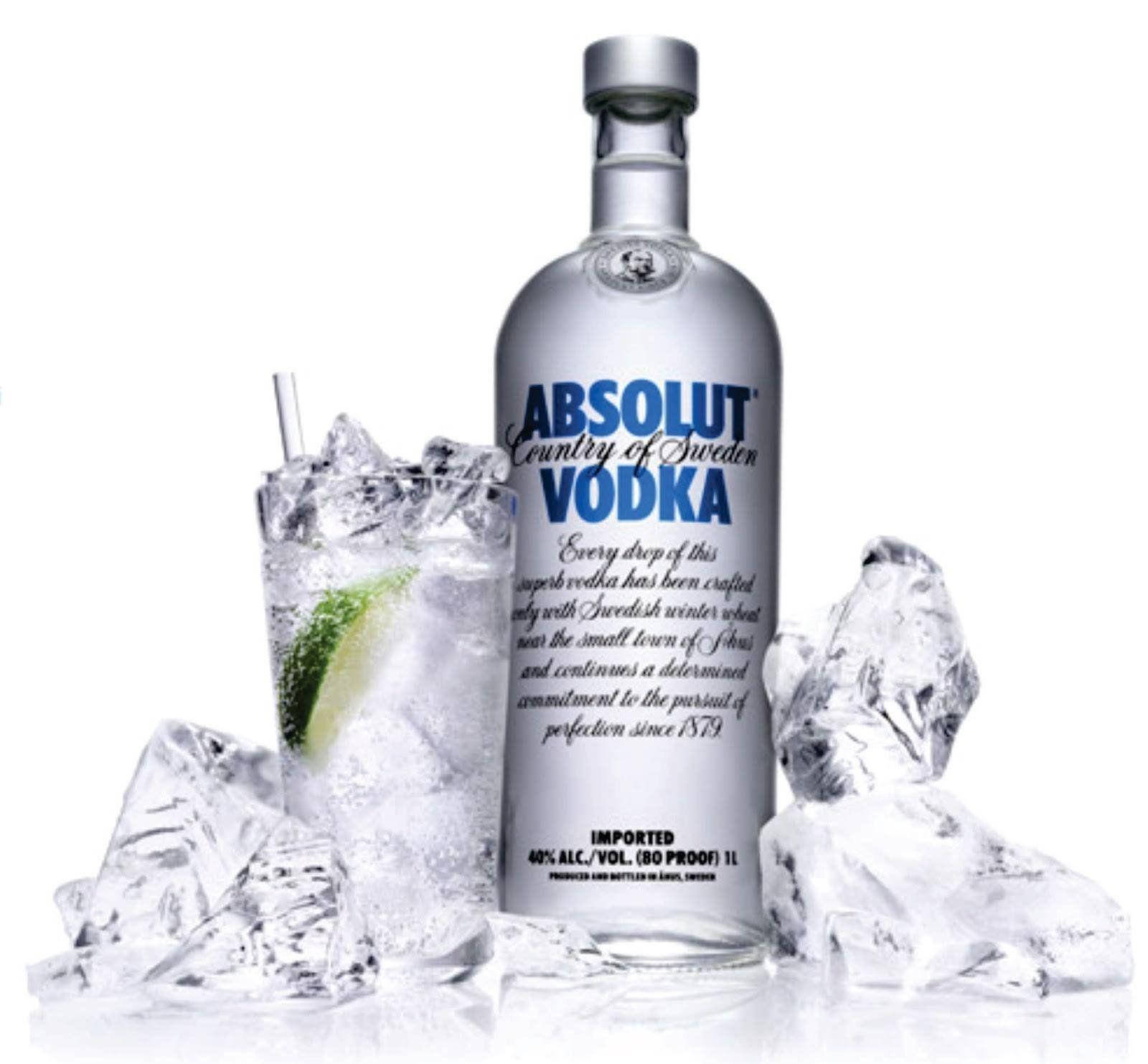 alcohol 桌布 壁紙 — 一個時尚的銀色Absolut Vodka酒瓶旁邊放著一杯加了萊姆和冰塊的伏特加，周圍散落著冰塊，置於白色反光表面上。
