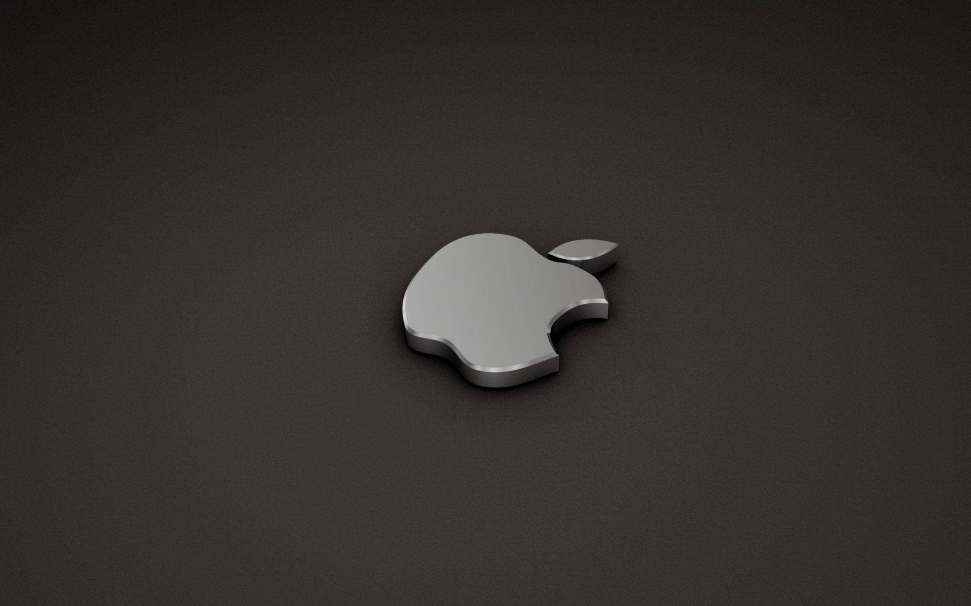 4K 桌布 壁紙 — 一個時尚的銀色Apple標誌居中放置在磨砂深灰色表面上，柔和的光線突顯其金屬邊緣。