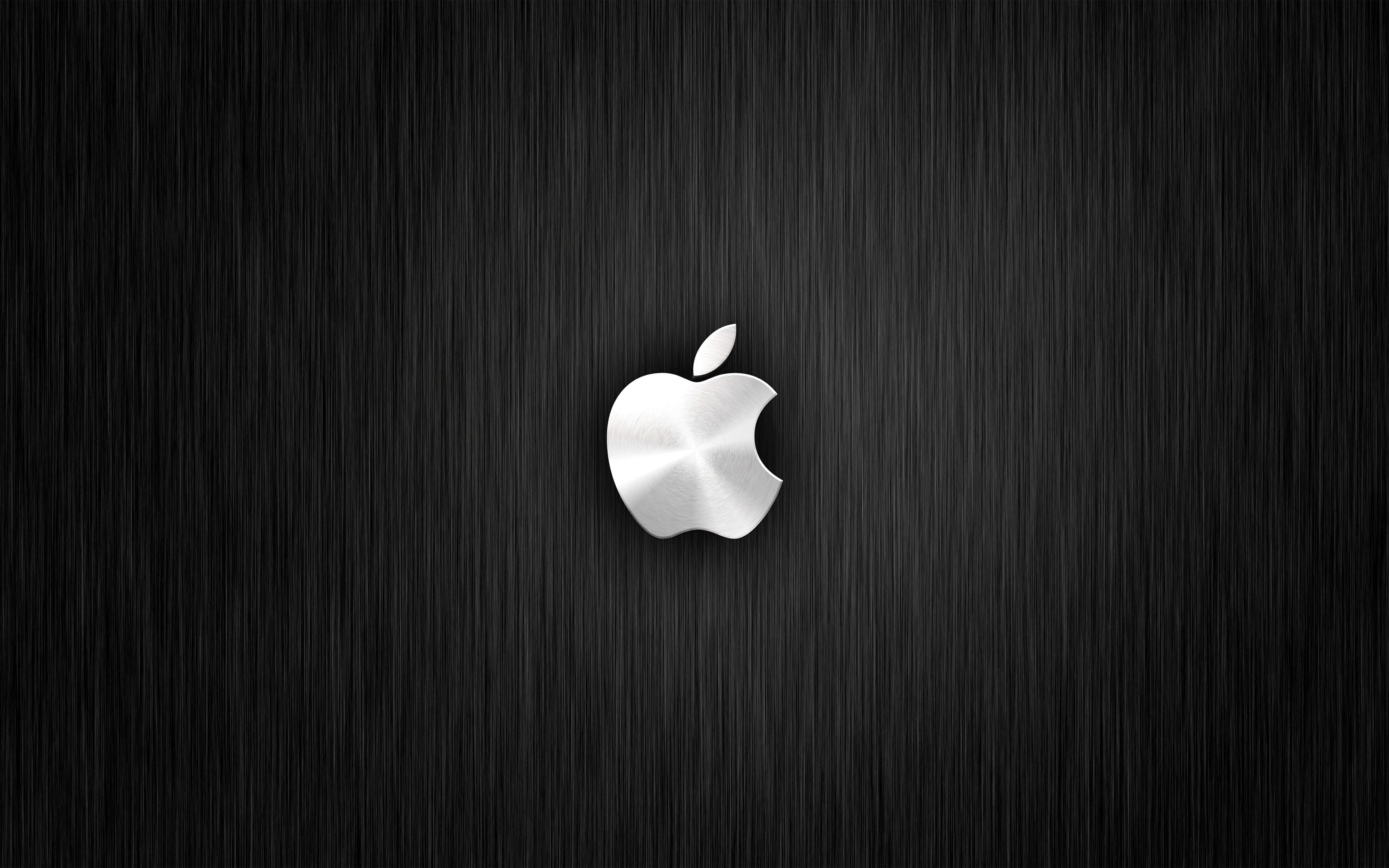 蘋果 桌布 壁紙 — 一個時尚的銀色Apple標誌居中於深色拉絲金屬背景上，帶有垂直紋理。