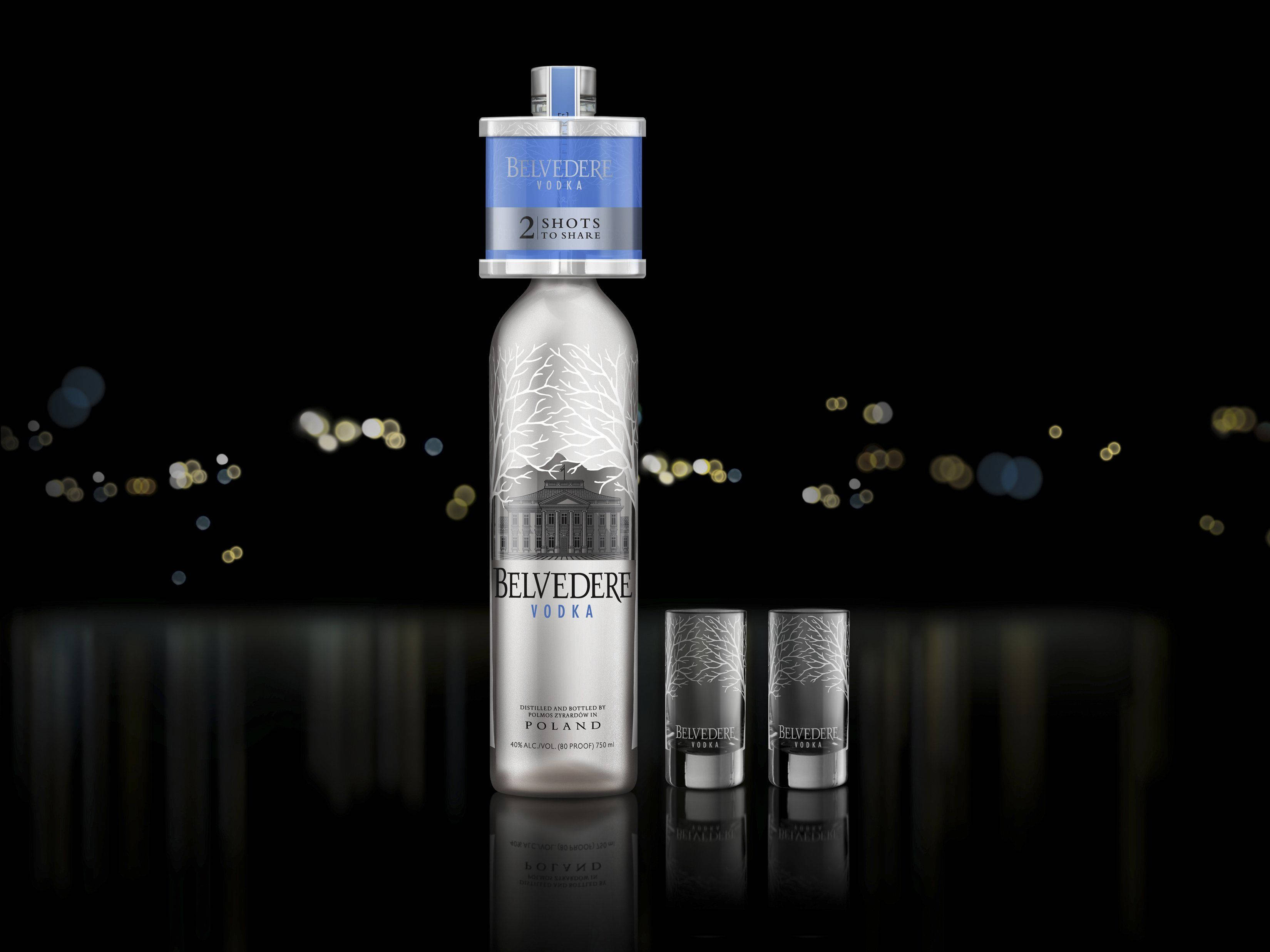 Drink 桌布 壁紙 — 一個時尚的銀色Belvedere伏特加酒瓶和兩個配套的玻璃杯，放在一個反射表面上，背景是黑色帶有金色散景燈光。