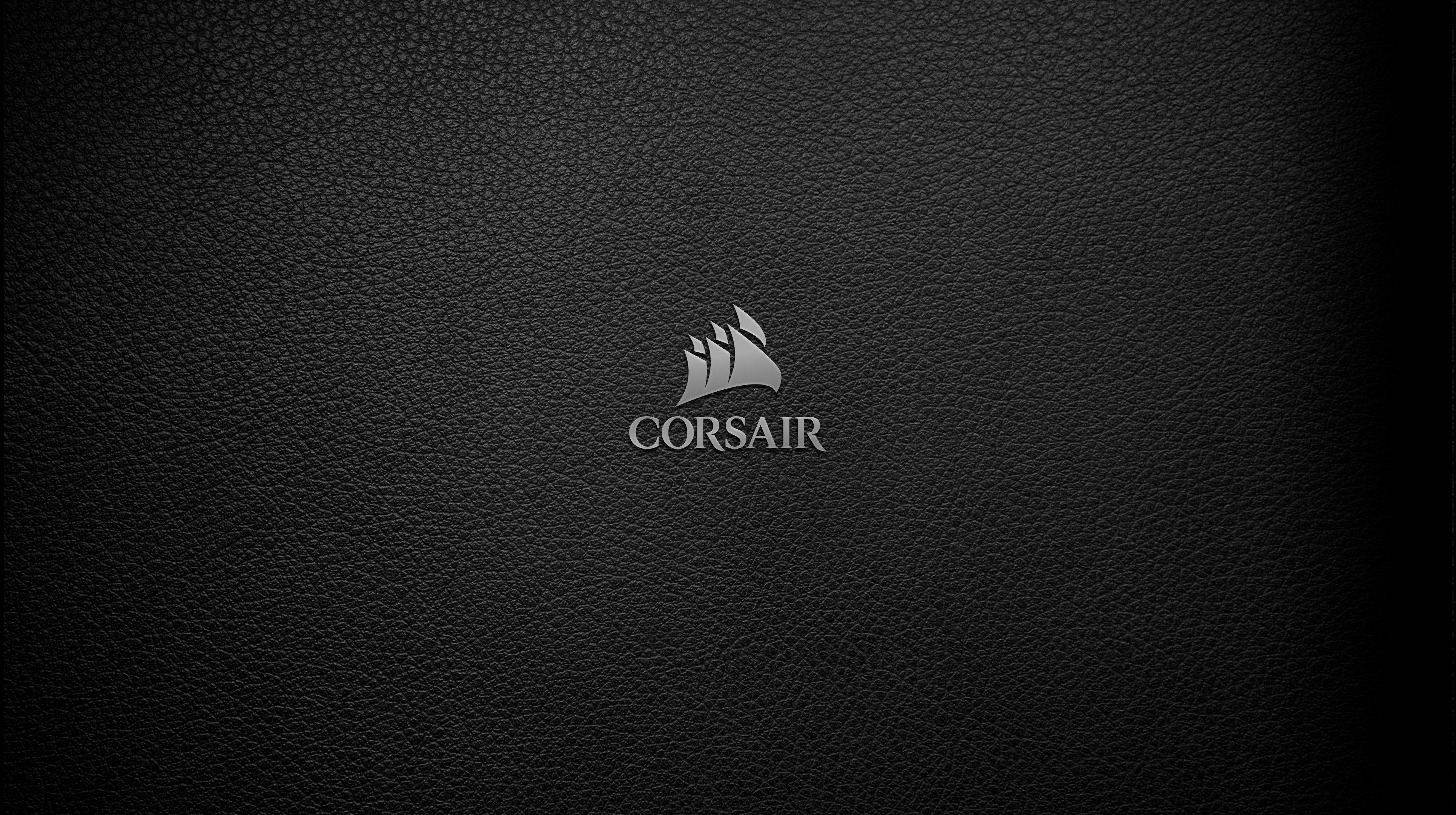 海盜船 桌布 壁紙 — 一個時尚的銀色Corsair標誌居中在帶有紋理的黑色皮革背景上，並帶有微妙的漸變照明。