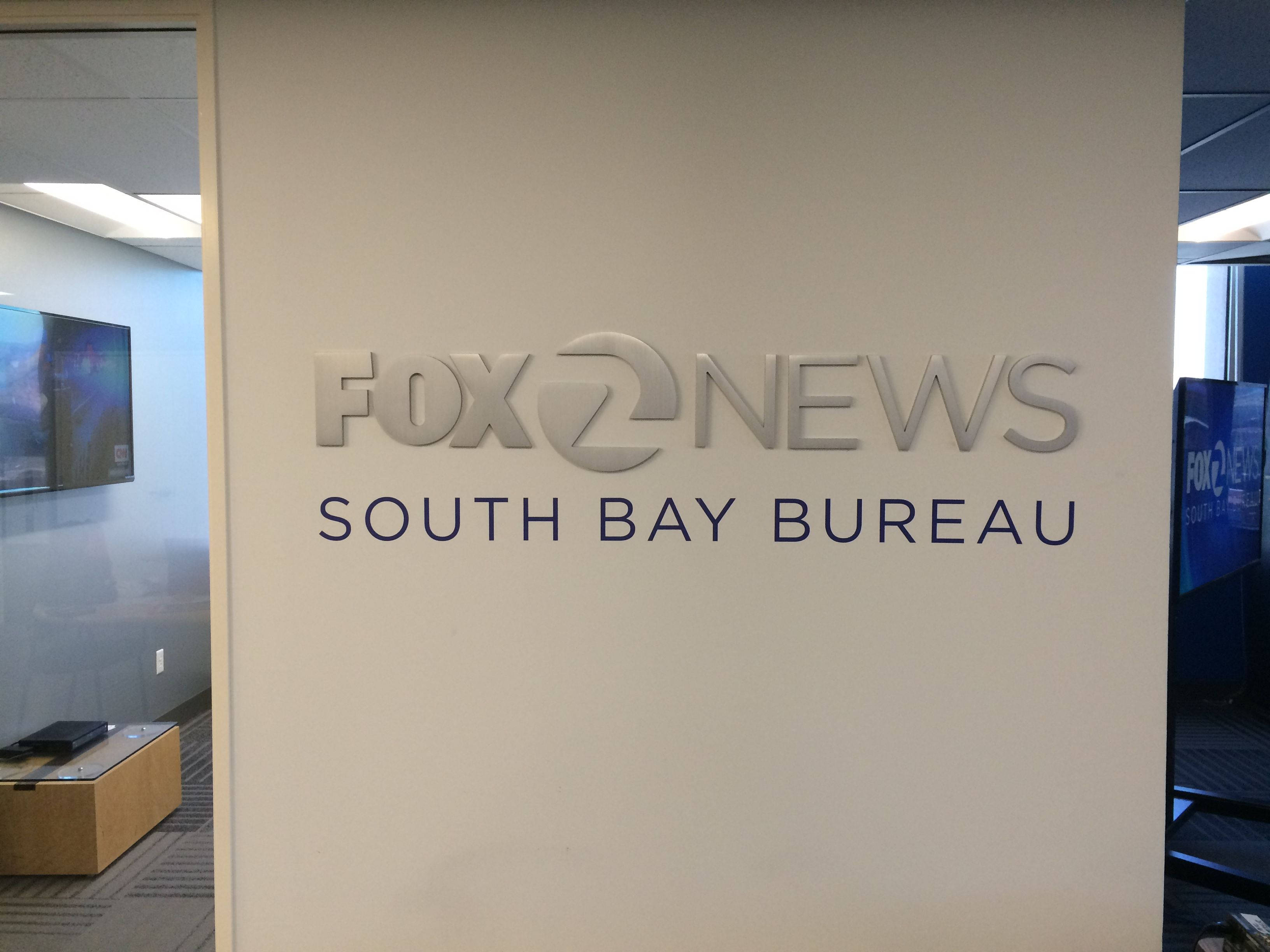 News 桌布 壁紙 — 一個時尚的銀色Fox News South Bay Bureau標誌安裝在現代辦公空間的米色牆上。
