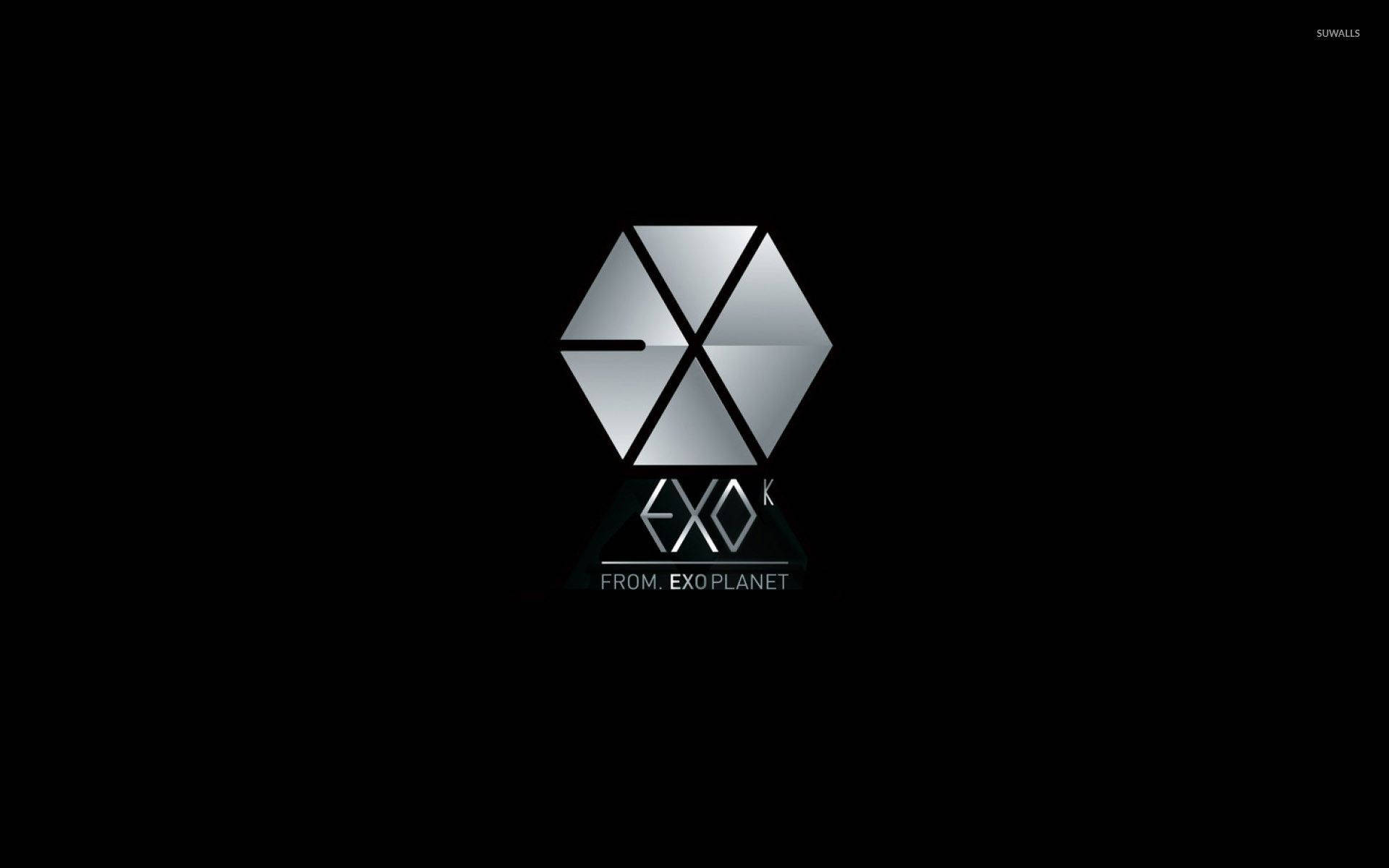 K-pop 桌布 壁紙 — 一個時尚的銀色六邊形EXO標誌，上面有「FROM EXO PLANET」文字，居中在黑色背景上。