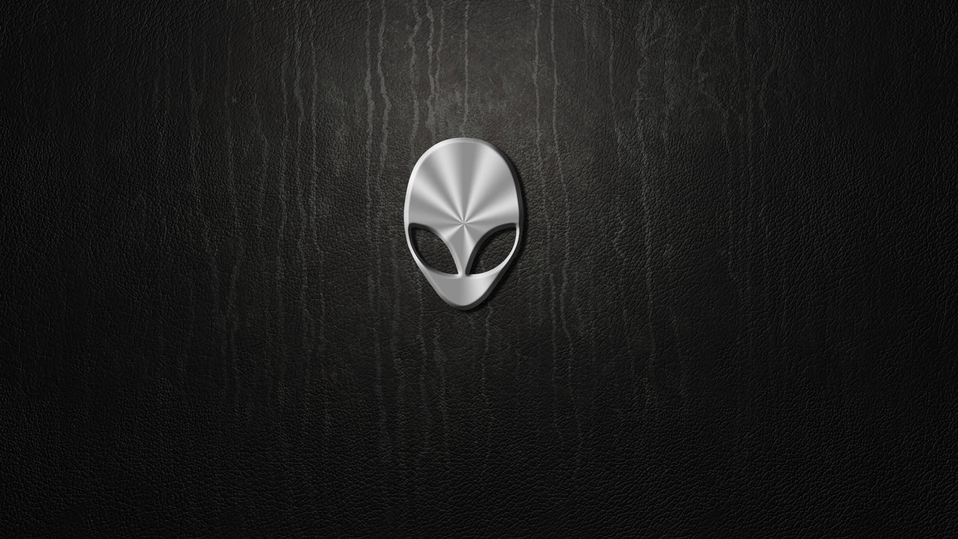 white alienware 桌布 壁紙 — 一個時尚的銀色外星人頭標誌，居中放置在帶有微妙照明的紋理黑色皮革表面上。