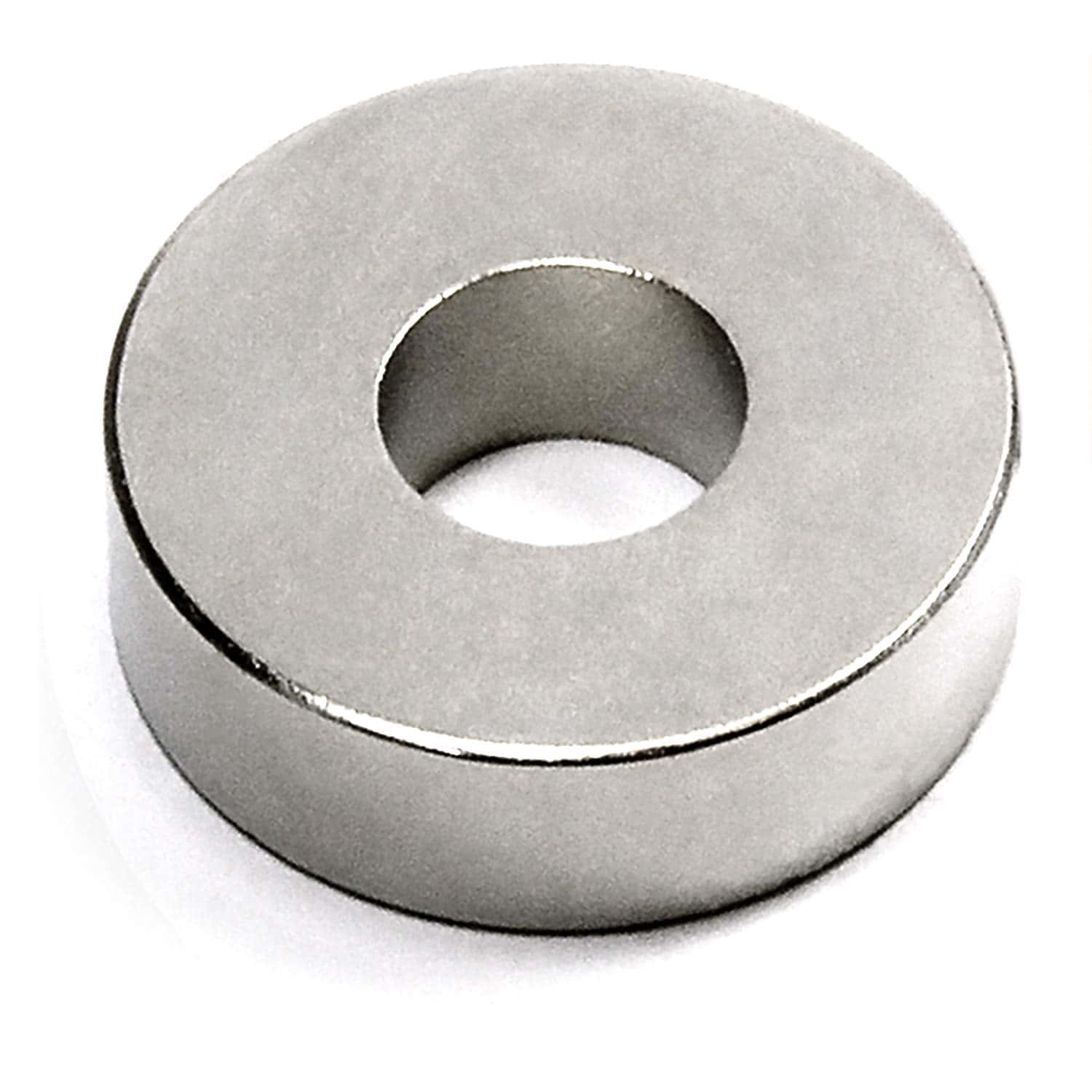 Material 桌布 壁紙 — 一個時尚的銀色環形磁鐵，中央有一個孔，在明亮的攝影棚燈光下放置在純白色的表面上。