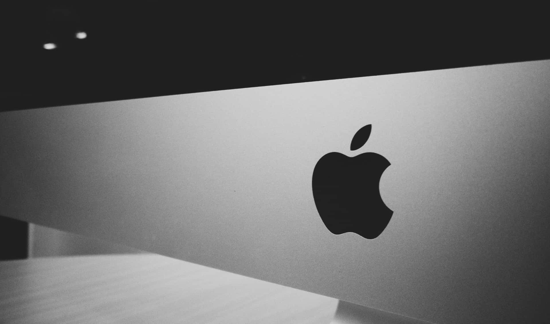 Black Apple Logo 桌布 壁紙 — 一個時尚的黑白特寫，Apple 標誌位於拉絲金屬表面，帶有柔和環境光。