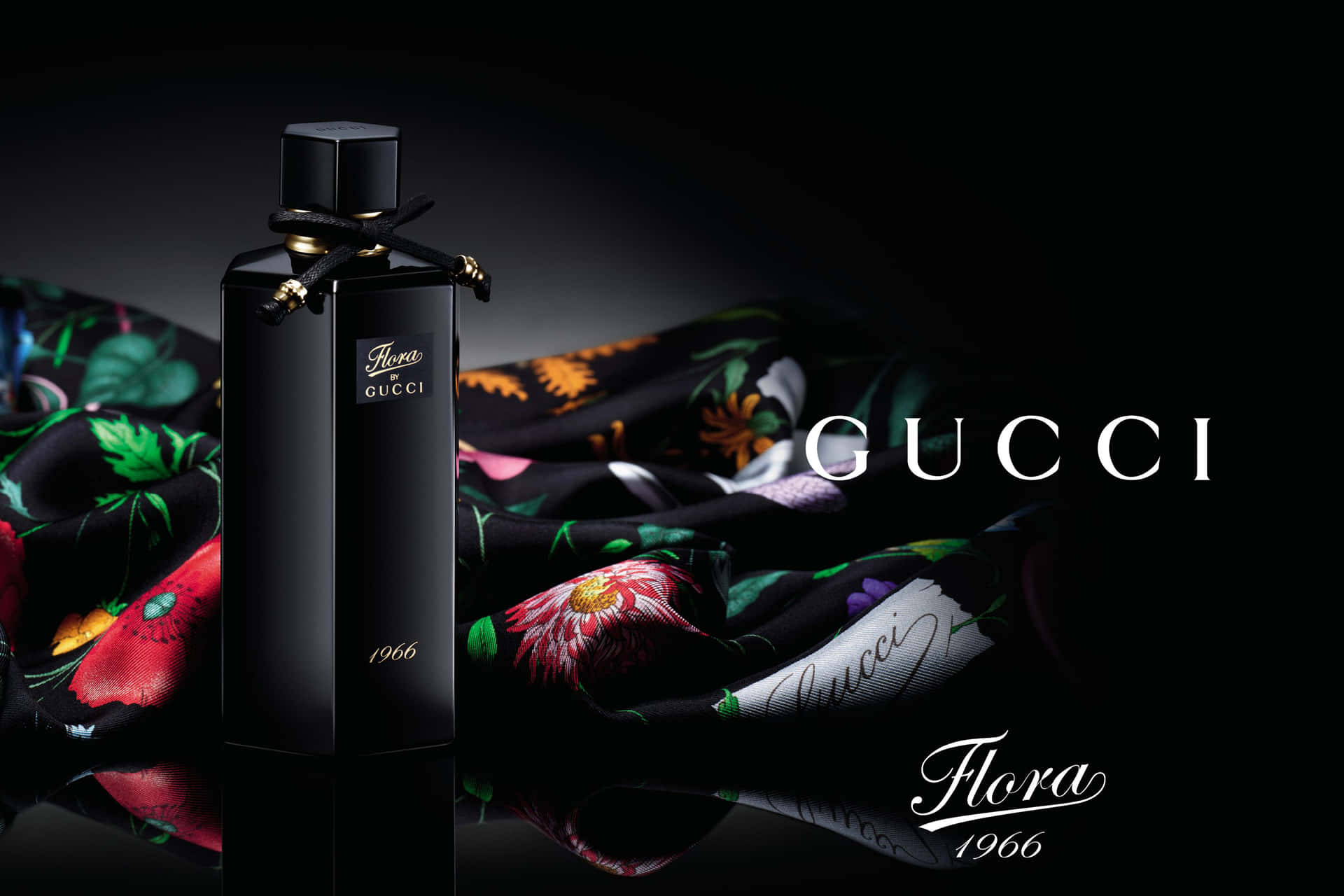 黑色 Gucci Flora 1966 香水瓶與花卉絲巾在反光表面上。 — Gucci GIF 壁紙