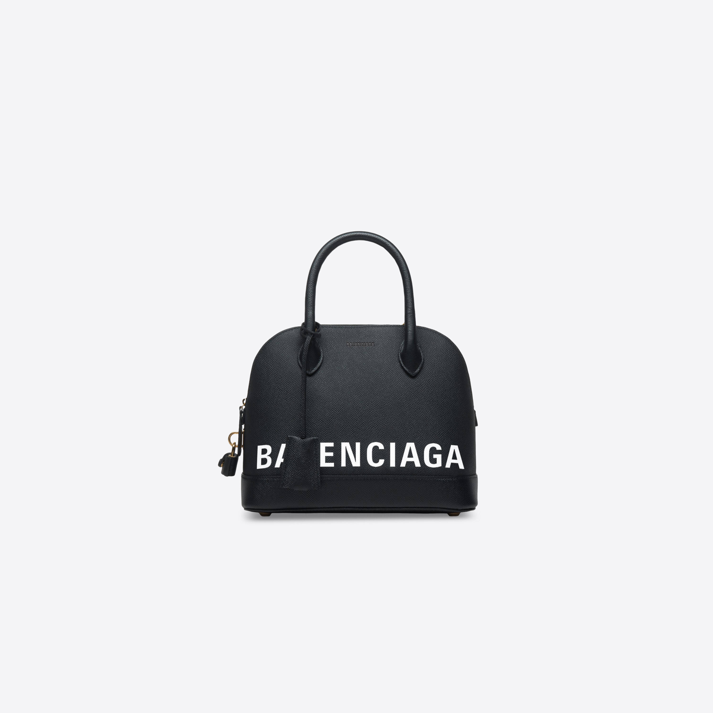 Balenciaga 桌布 壁紙 — 一個時尚的黑色Balenciaga手提包，帶有粗體白色標誌文字和金色五金件，背景為純白色。