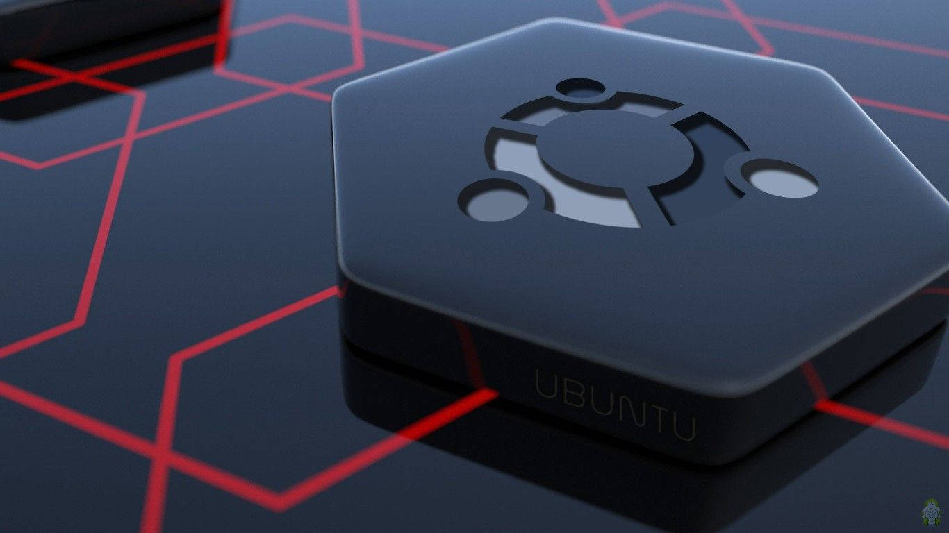 ubuntu 桌布 壁紙 — 一個時尚的黑色六角形Ubuntu裝置放置在光滑的表面上，帶有發光的紅色幾何線條。