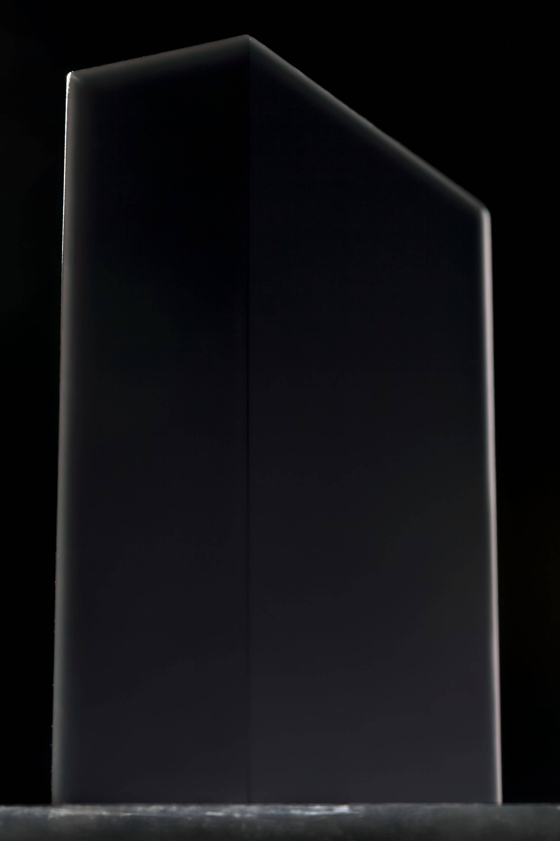 black aesthetic tumblr iPhone 桌布 壁紙 — 一個時尚的黑色幾何塊孤立地立在純黑色背景上，微妙的亮點定義了其銳利的邊緣。