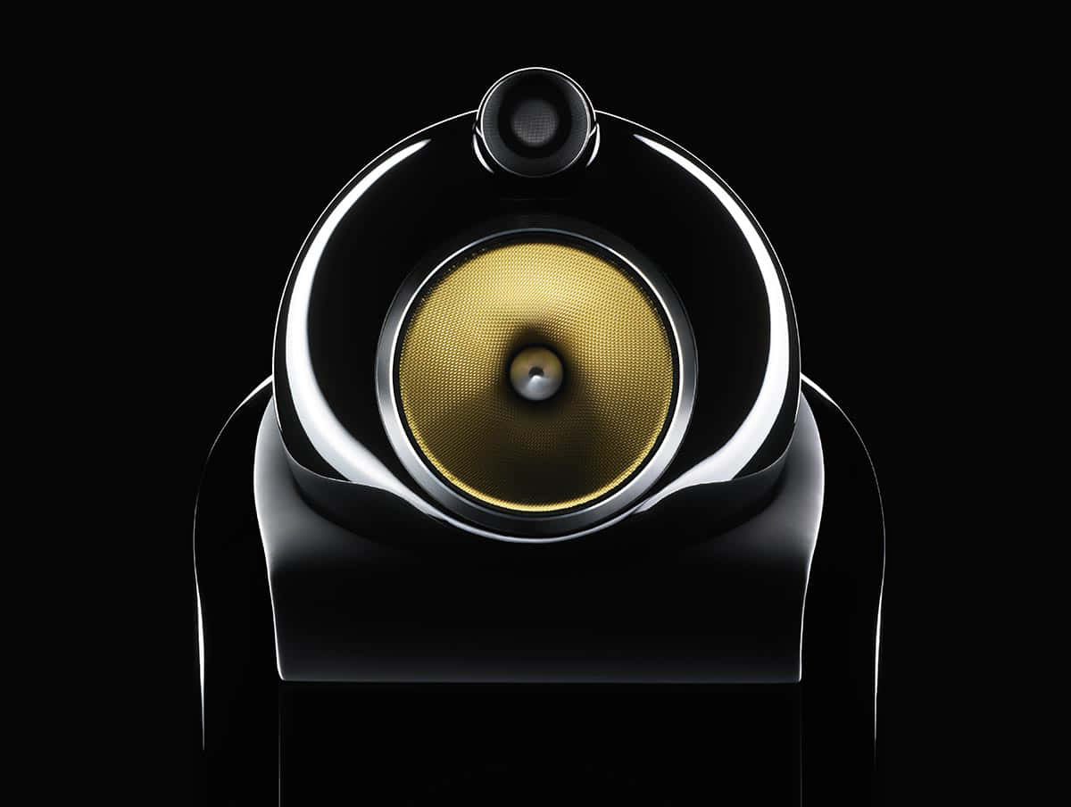Speaker 桌布 壁紙 — 一個時尚的黑色揚聲器，帶有金色錐體和鍍鉻裝飾，居中放置在純黑色背景上。