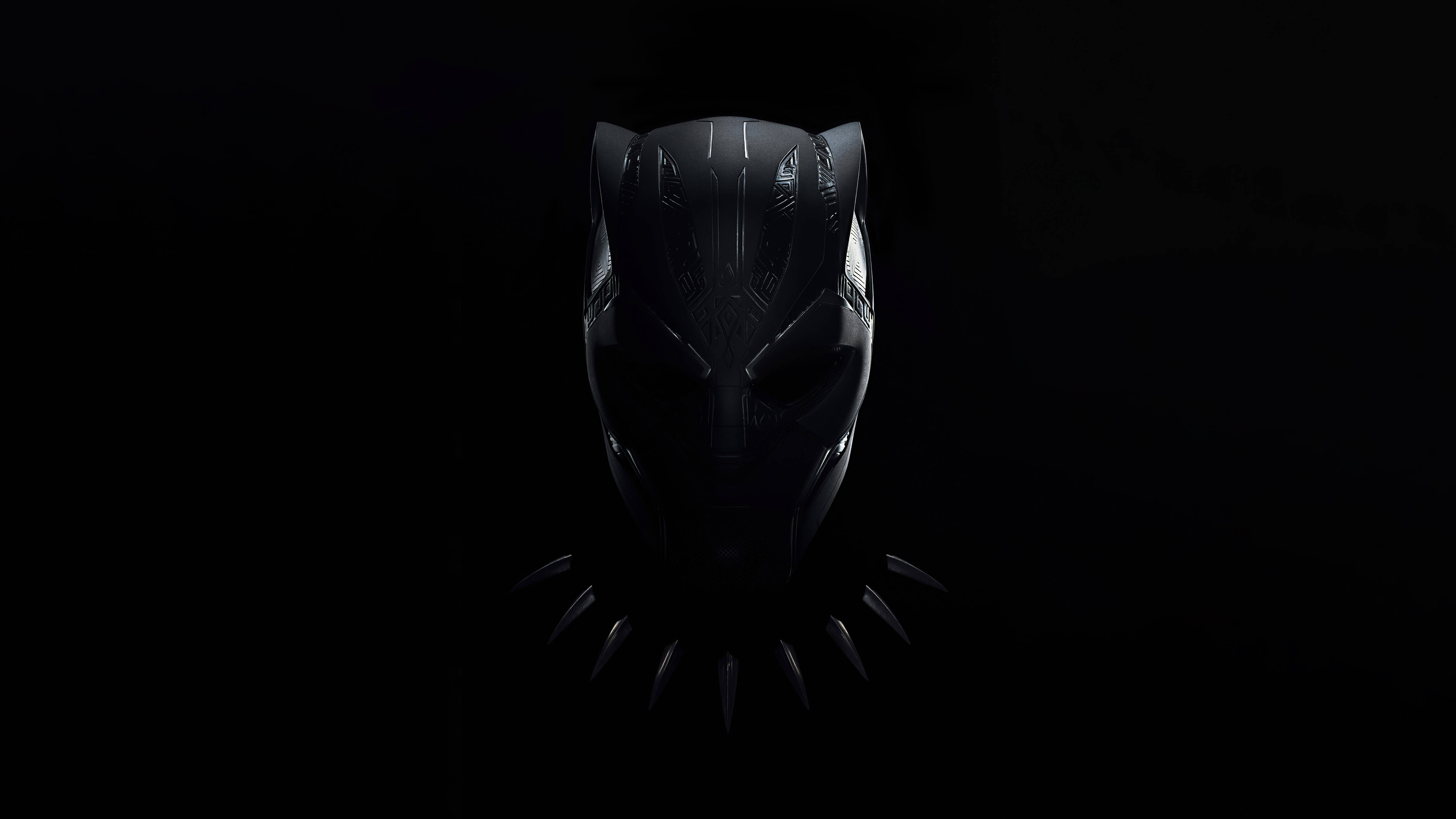 Wakanda 桌布 壁紙 — 一個時尚的黑色豹子面具在漆黑背景上微微發光，下方有鋒利的爪狀突起。