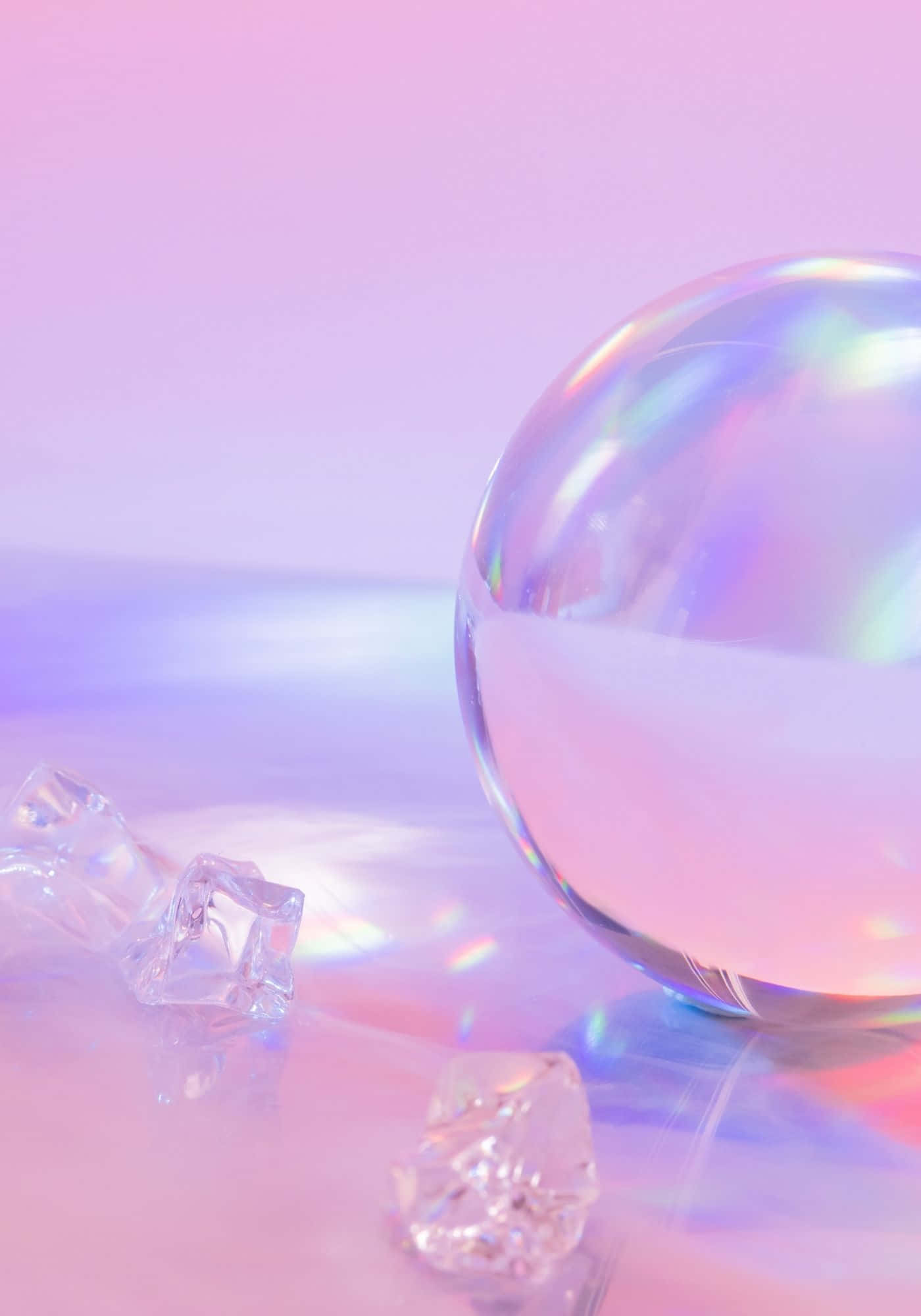 Bubble 桌布 壁紙 — 一個有光澤的球體和水晶碎片在柔和的粉紅色和紫色漸變表面上反射出彩虹色的光。