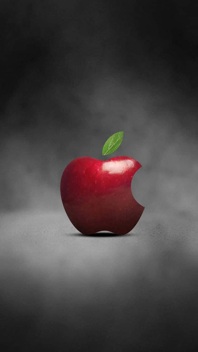 iPhone X Apple Logo 桌布 壁紙 — 一個有光澤的紅蘋果，上面有一個咬痕和綠葉，位於煙霧般的深灰色背景中央。