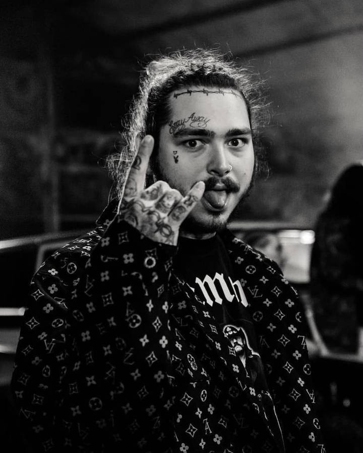 Post Malone 桌布 壁紙 — 一個有刺青、留鬍子的男人做出手勢並伸出舌頭的黑白肖像。