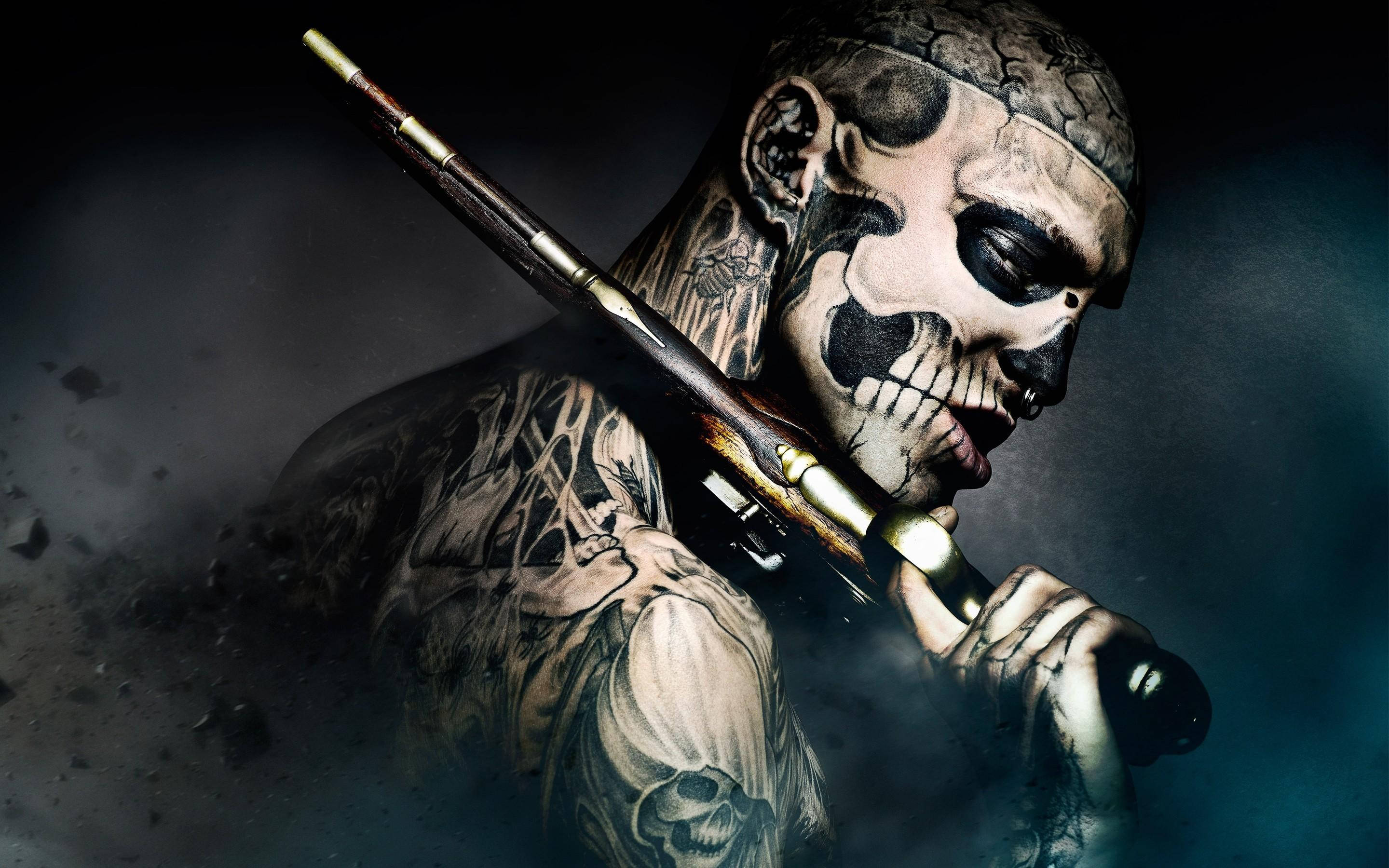 Tattoo 桌布 壁紙 — 一個有刺青、臉上畫著骷髏妝的男人，在煙霧瀰漫的黑暗中，在戲劇性的燈光下拿著步槍。