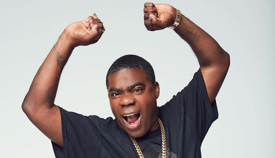 Tracy Morgan 桌布 壁紙 — 一個有刺青和戴金鏈的男人在純白色背景前高舉雙拳，發出勝利的呼喊。