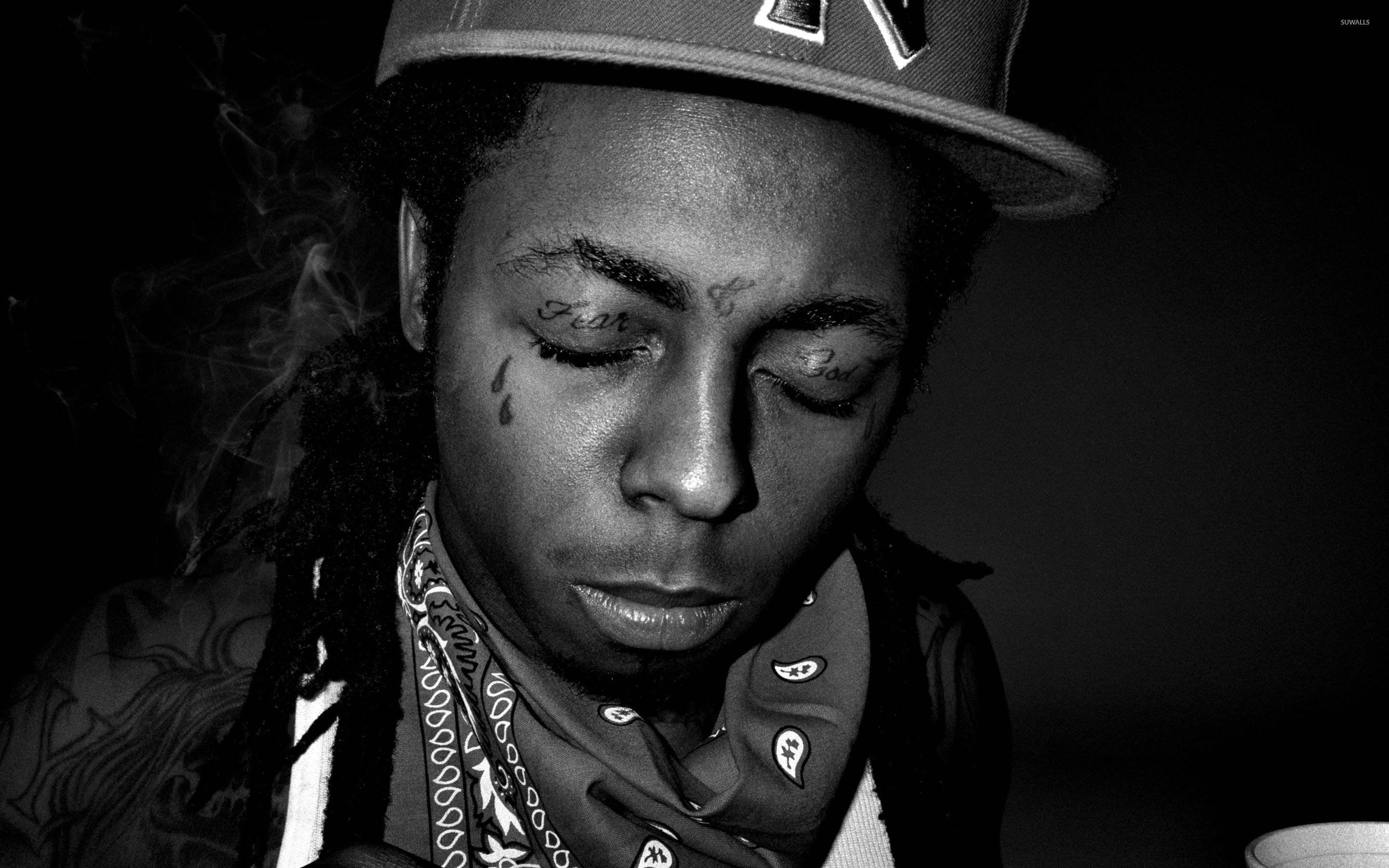 Lil Wayne 桌布 壁紙 — 一個有刺青和頭巾的男人在昏暗燈光下抽煙的黑白肖像。
