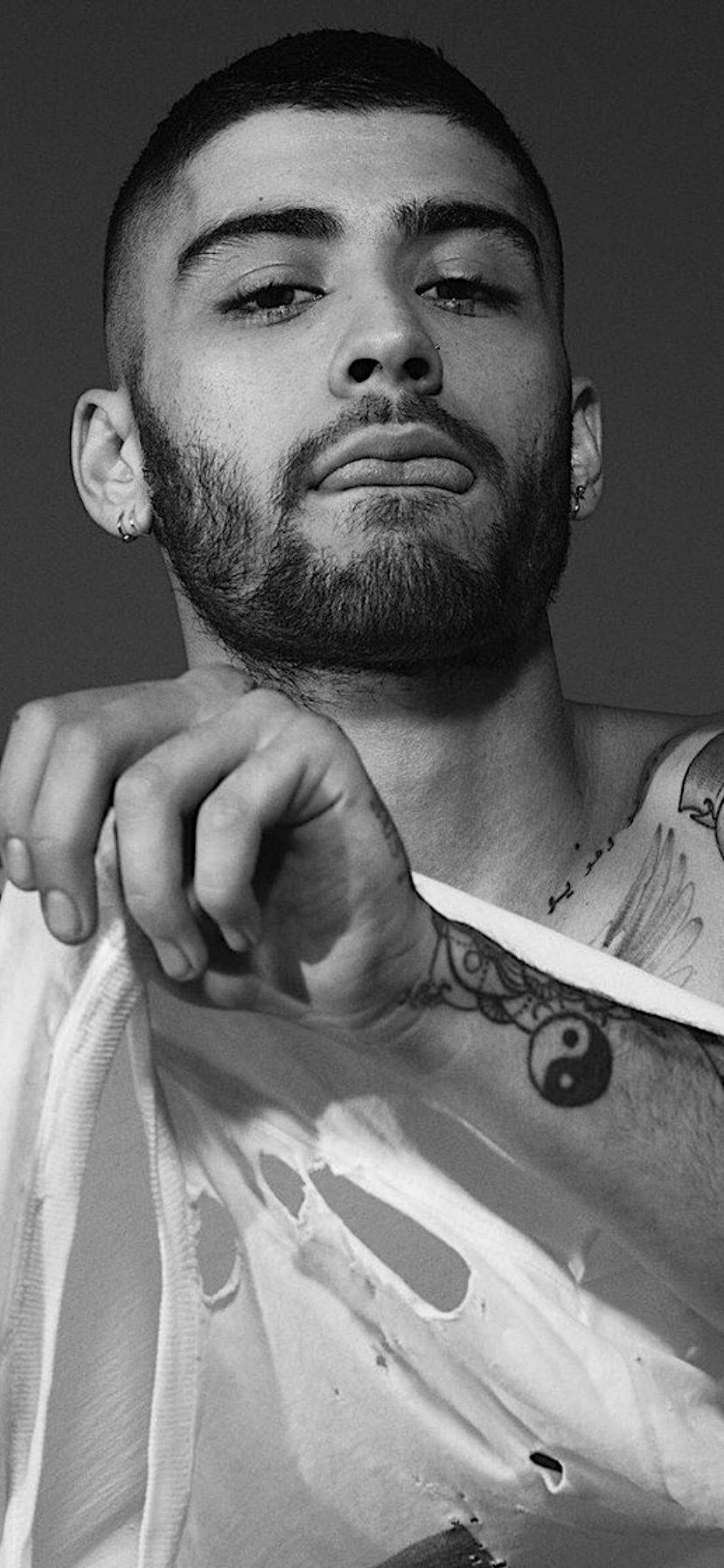 Celebrity 桌布 壁紙 — 一個有刺青和鬍鬚的男人的黑白肖像，直視鏡頭，表情嚴肅。