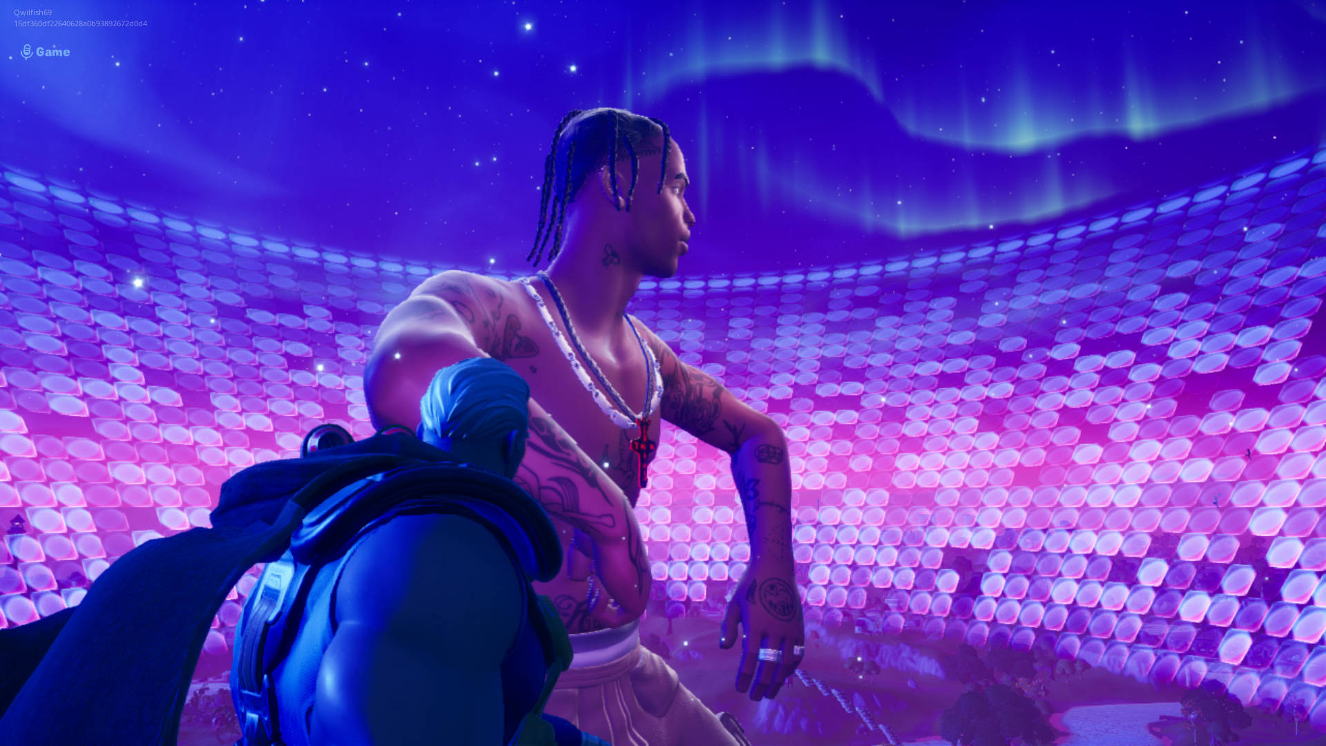 Travis Scott Fortnite 桌布 壁紙 — 一個有刺青的Fortnite角色站在發光的紫色競技場中，上方是星光燦爛的極光天空。