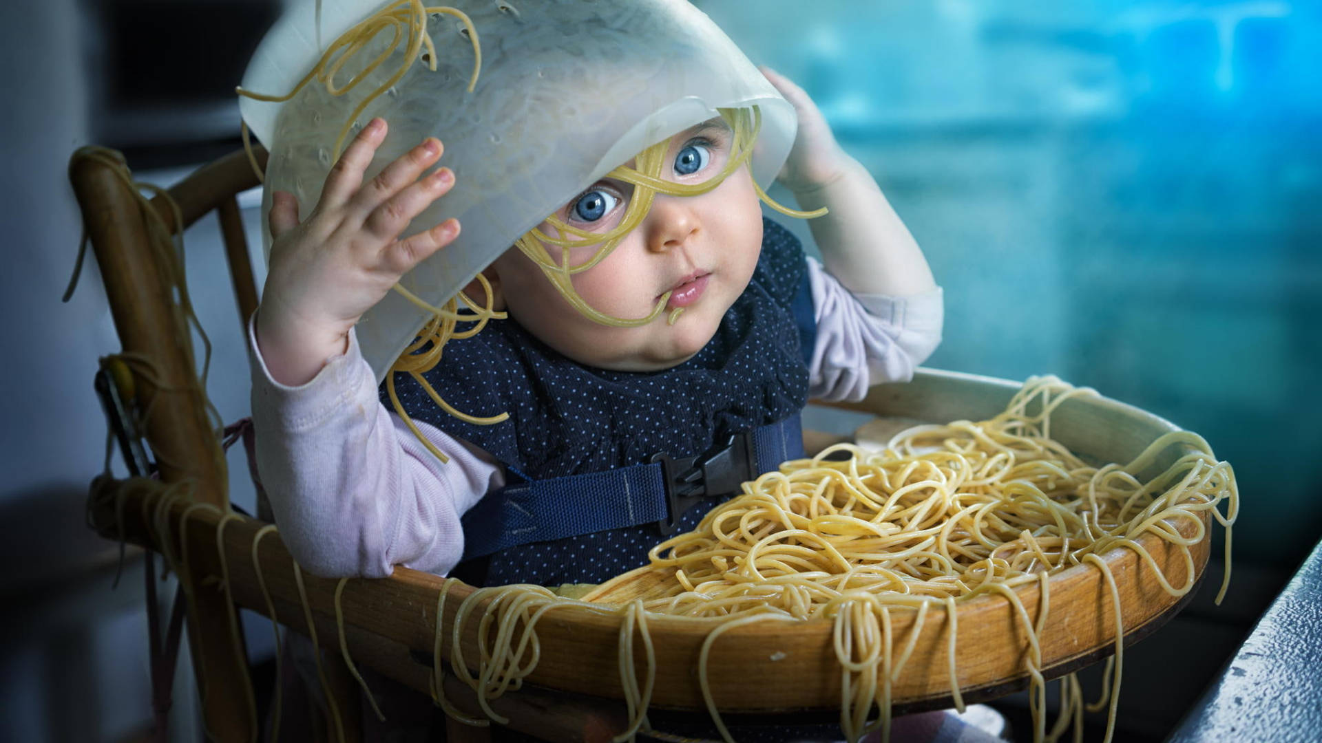 Pasta 桌布 壁紙 — 一個有寬闊藍眼睛的嬰兒坐在一個被義大利麵條覆蓋的木製高腳椅上，戴著麵條帽子。