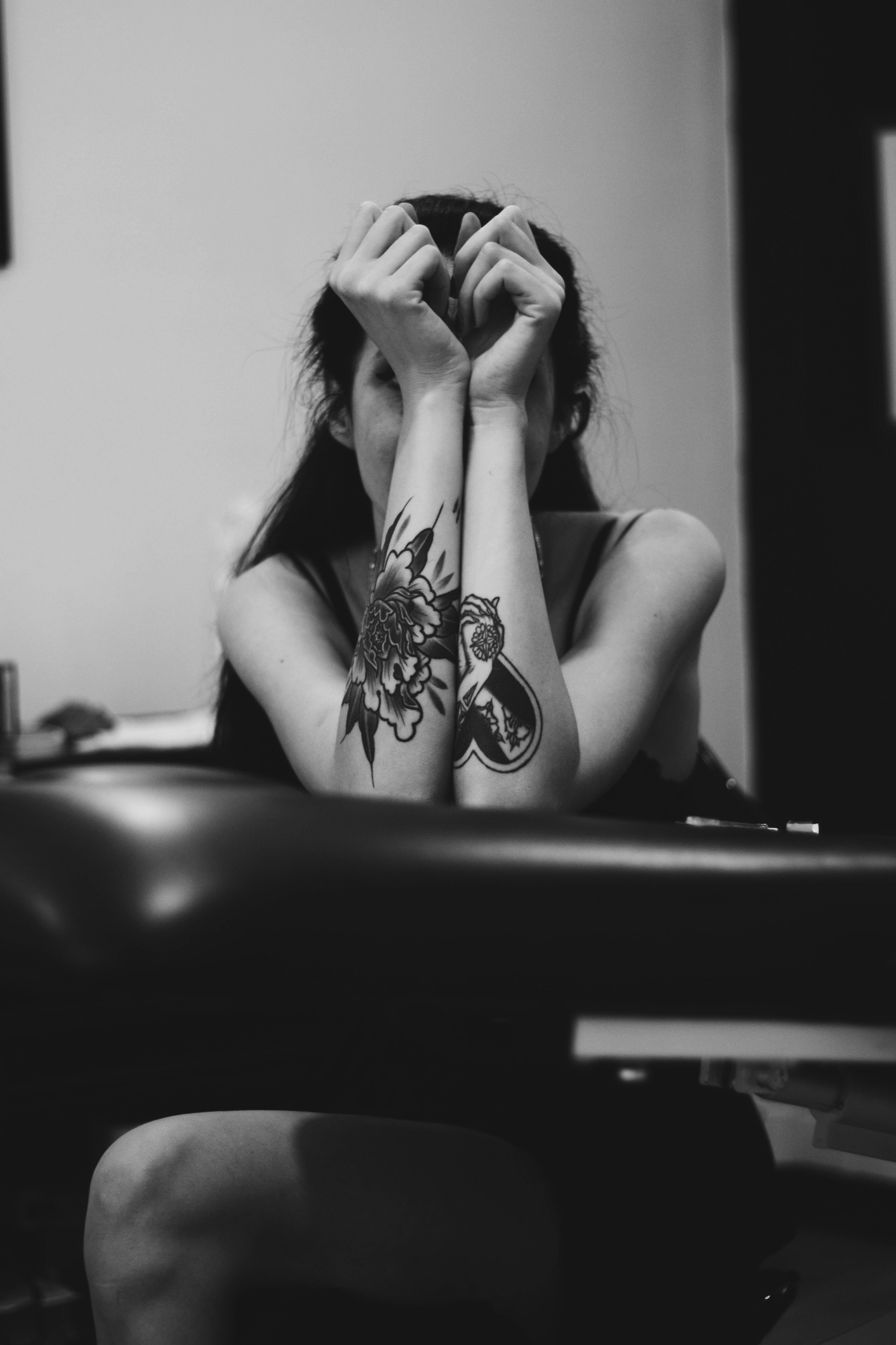 Tattoo 桌布 壁紙 — 一個有明顯刺青的人，在室內黑白鮮明的環境中用手遮住臉。