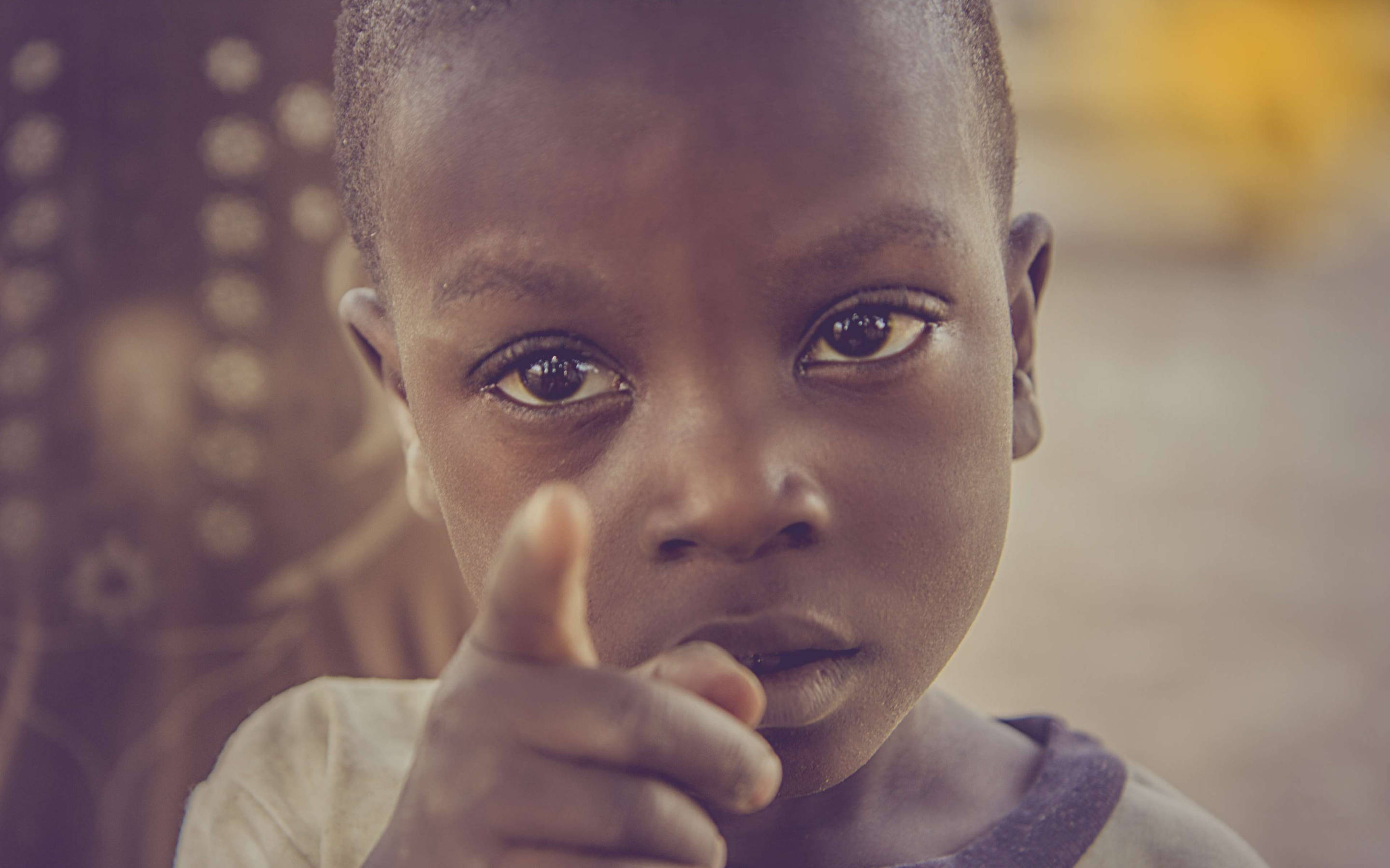 Nigeria 桌布 壁紙 — 一個有深色眼睛和短髮的小孩，表情嚴肅地直接指向相機。