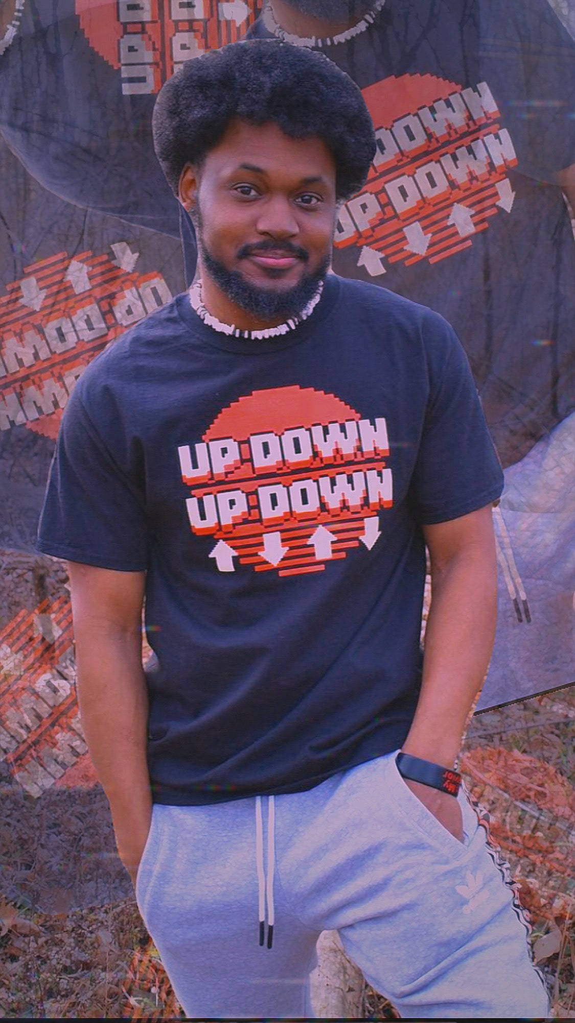 Coryxkenshin 桌布 壁紙 — 一個有爆炸頭和鬍鬚的男人，穿著印有「UP DOWN」文字和箭頭的黑色T恤，靠在塗鴉牆上。