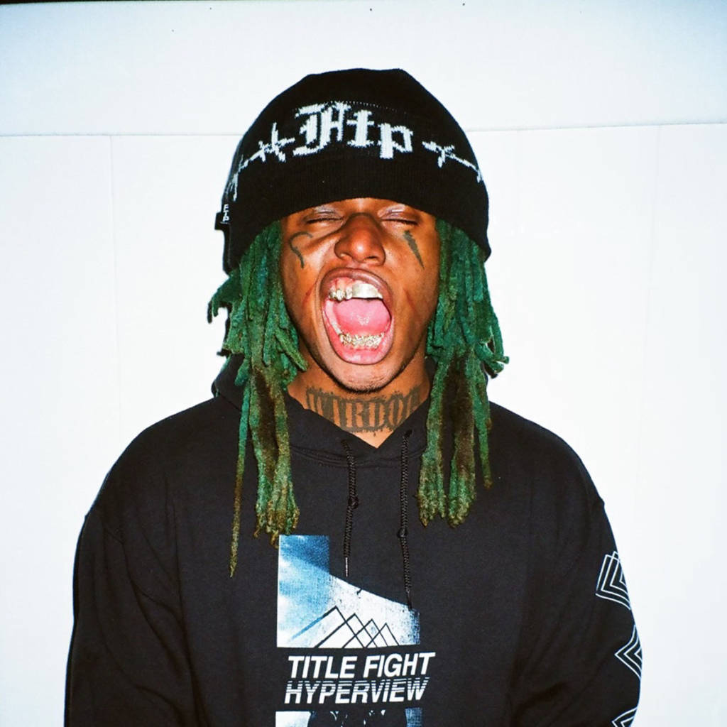 Zillakami 桌布 壁紙 — 一個有綠色辮子頭和黑色冷帽的男人，對著純白牆壁張大嘴巴尖叫。