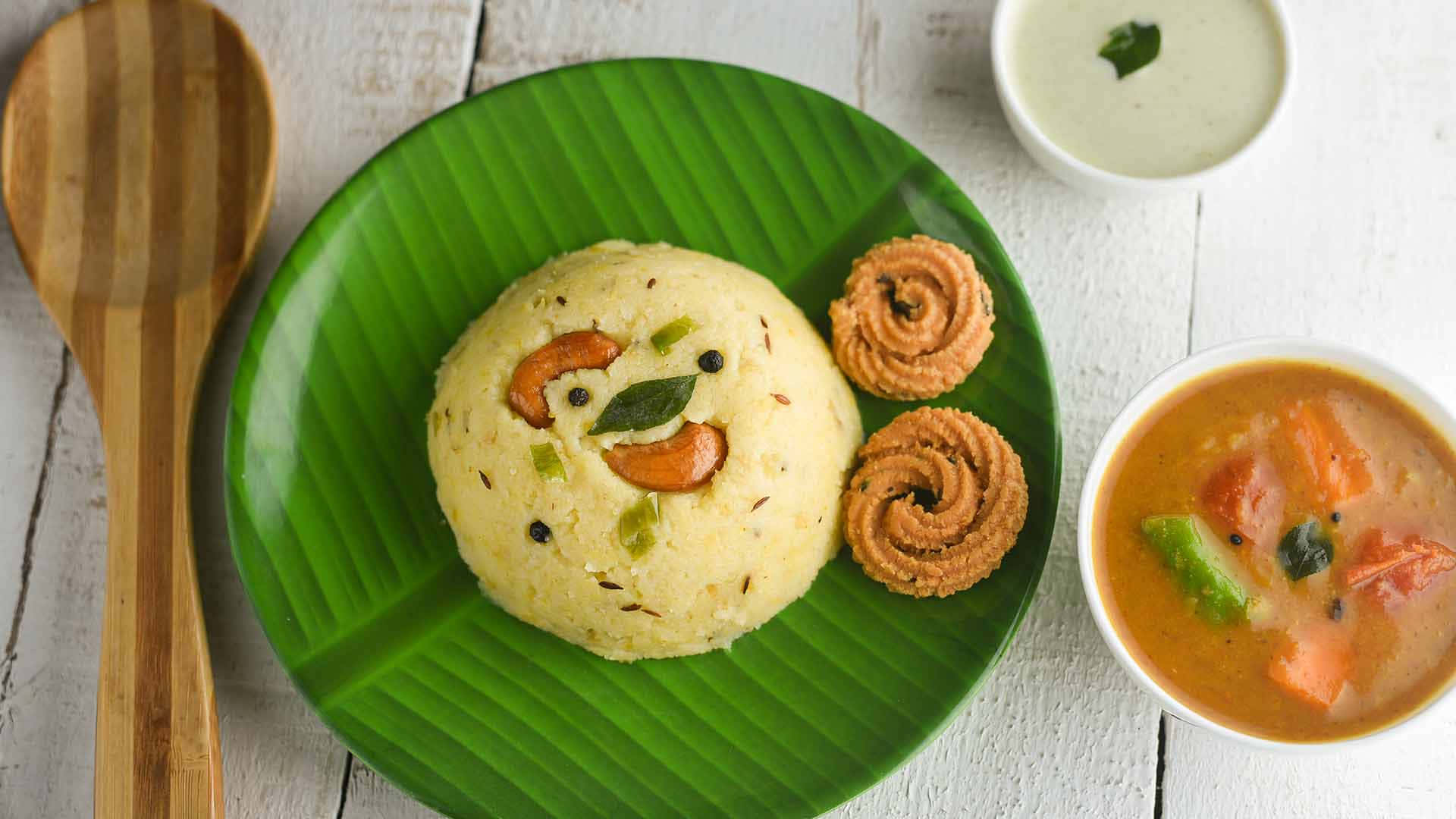 Pongal 桌布 壁紙 — 一個有趣的黃色米飯菜餚，形狀像笑臉，放在綠色香蕉葉盤子上，配有漩渦餅乾和兩碗咖哩和酸辣醬。