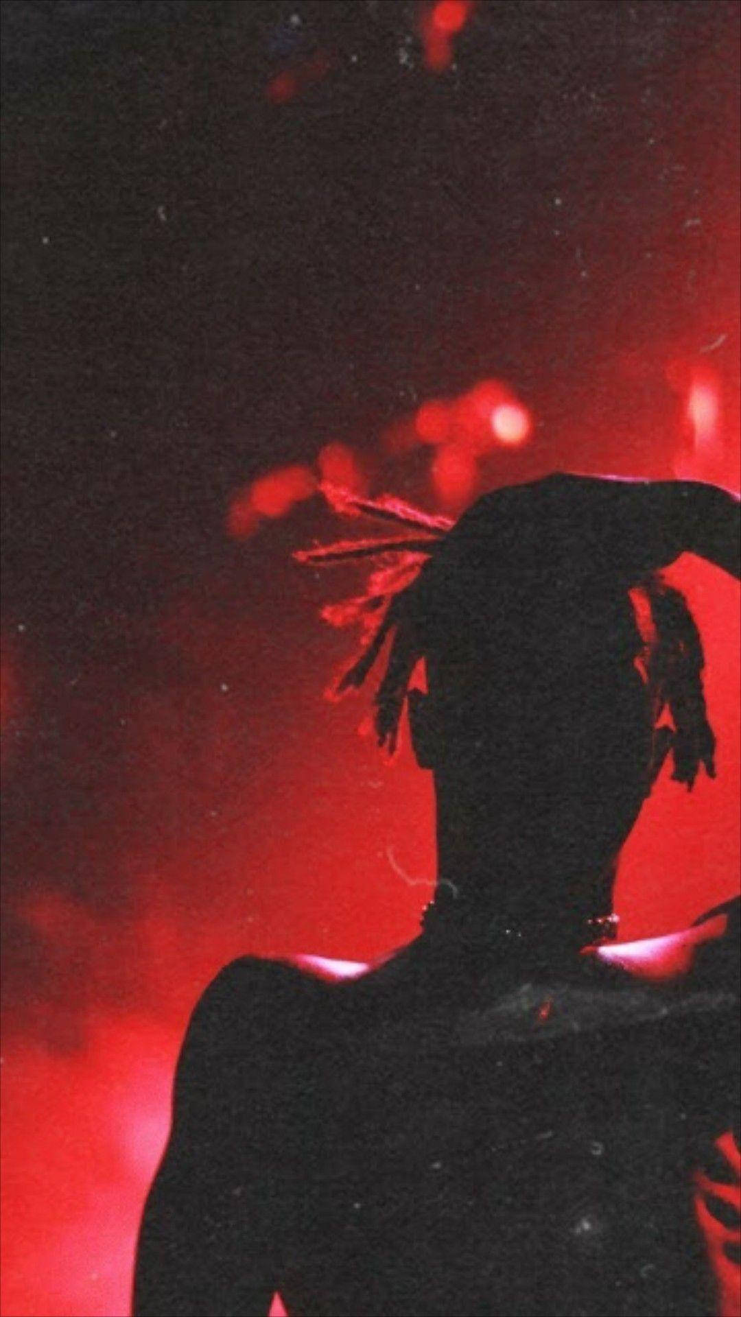 XXXTENTACION 桌布 壁紙 — 一個有辮子的人的剪影，背景是發光的紅色朦朧背景。