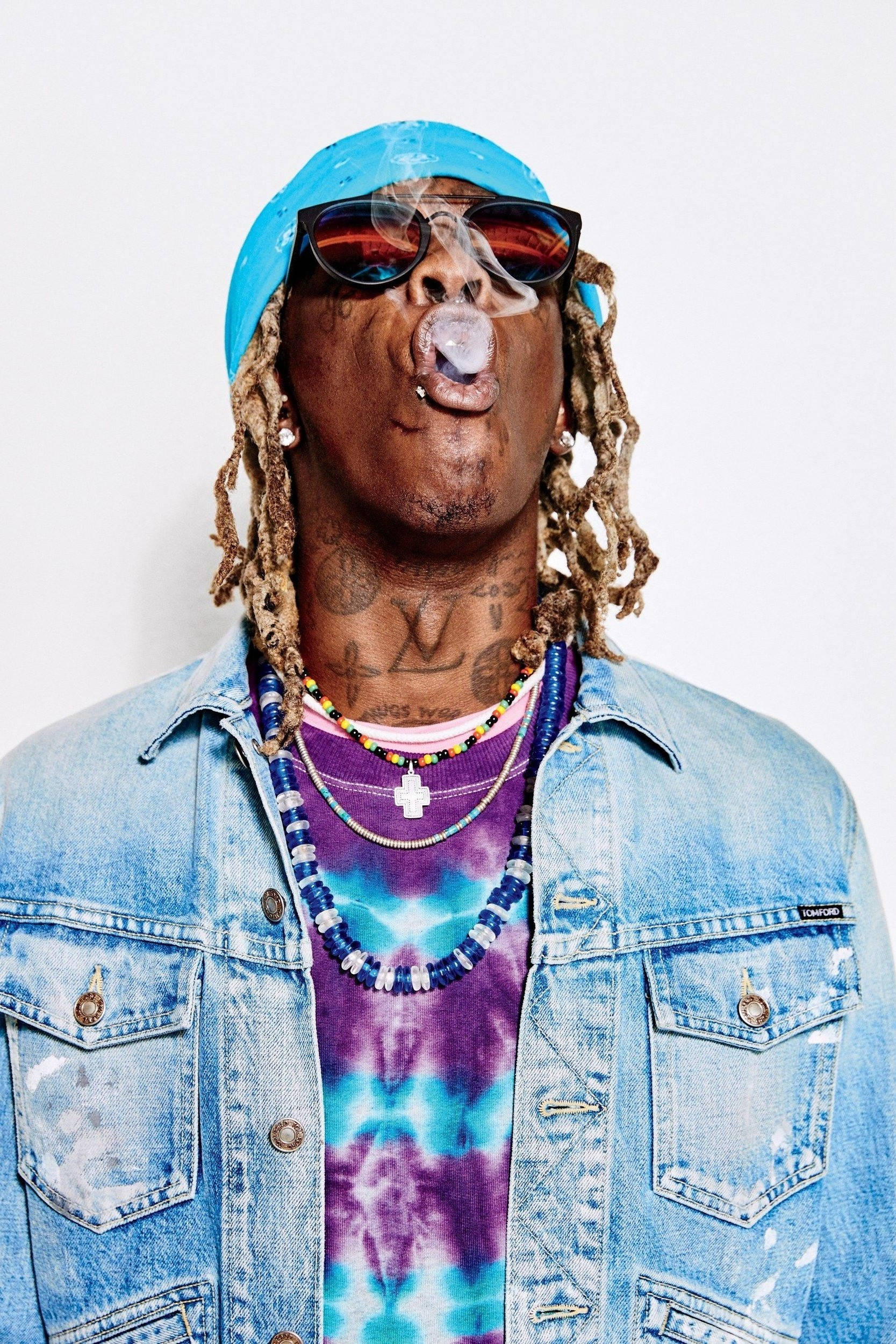 Thug 桌布 壁紙 — 一個有辮子頭和刺青的男人，戴著太陽眼鏡和牛仔外套，在純白色背景前吹泡泡。