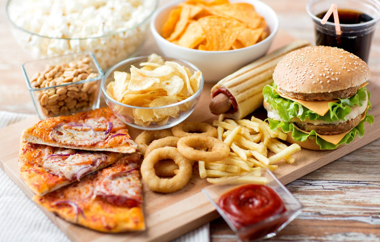 Burger 桌布 壁紙 — 一個木板上堆滿經典電影零食，包括漢堡、薯條、洋蔥圈和爆米花。