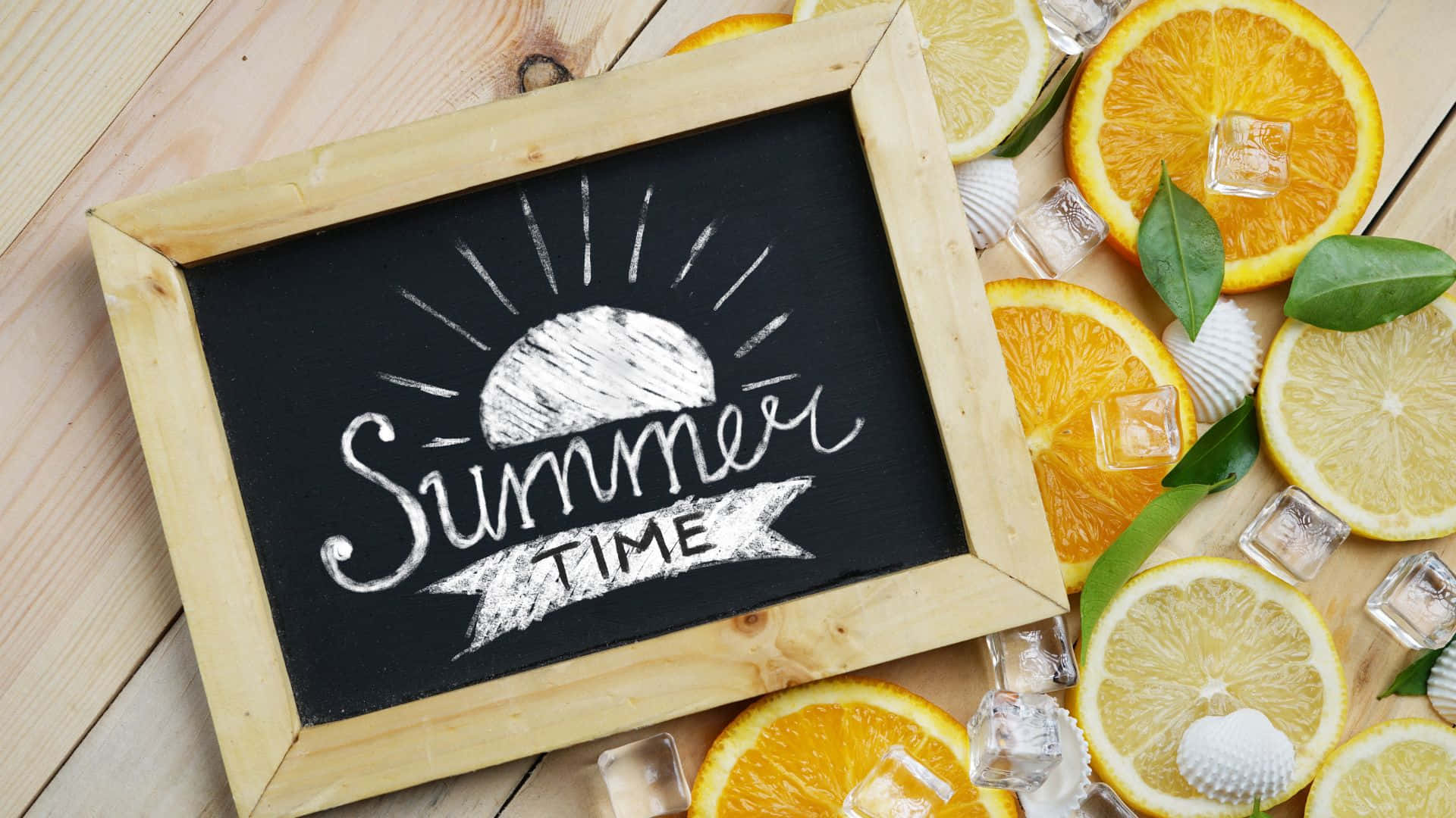 夏天 桌布 壁紙 — 一個木框黑板，上面用白色粉筆寫著「Summer Time」，周圍有柑橘片、冰塊和貝殼，放在淺色木質表面上。
