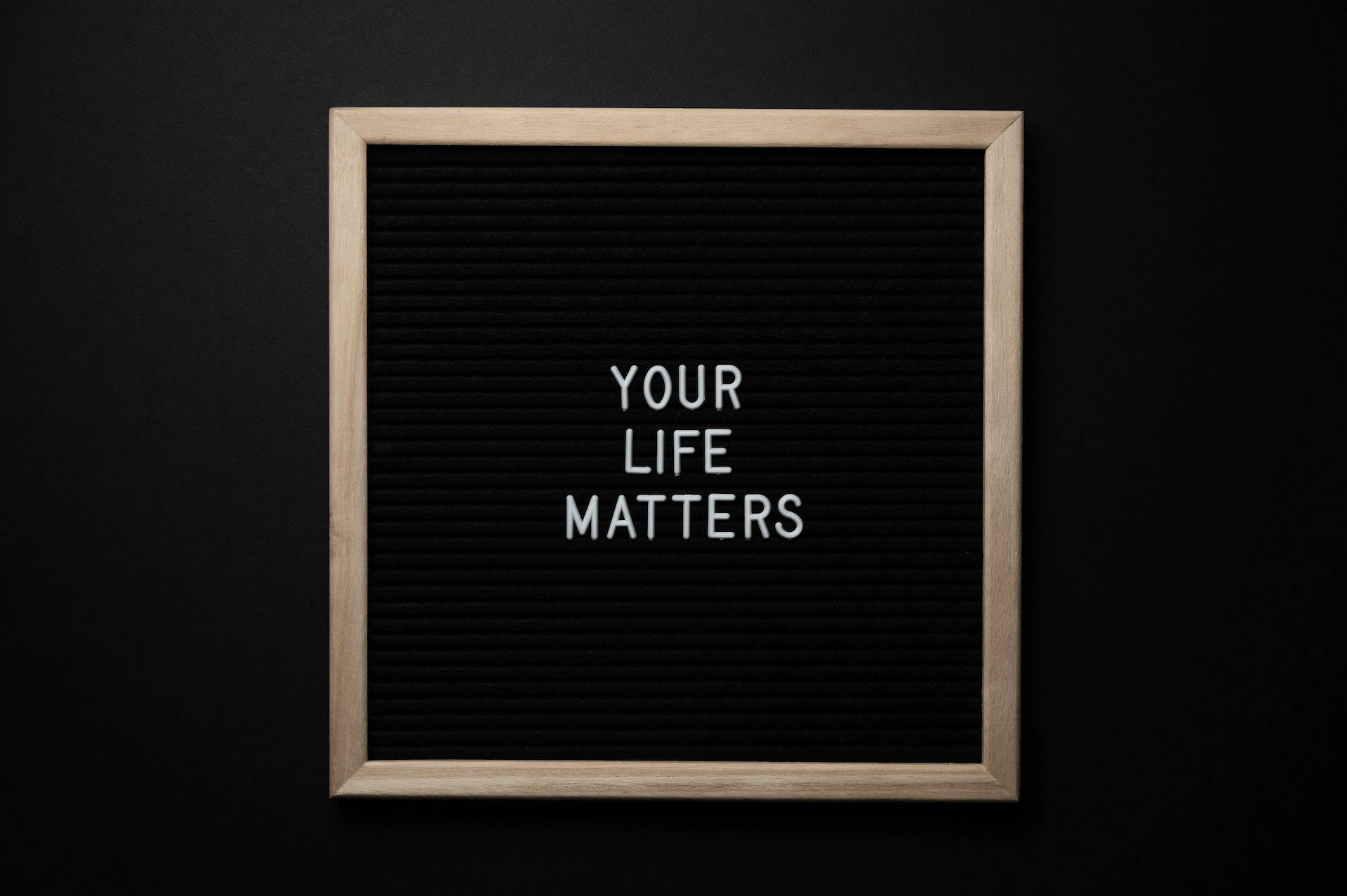 Positive Quotes 桌布 壁紙 — 一個木框黑色氈板在深色背景上以白色字母顯示訊息「YOUR LIFE MATTERS」。