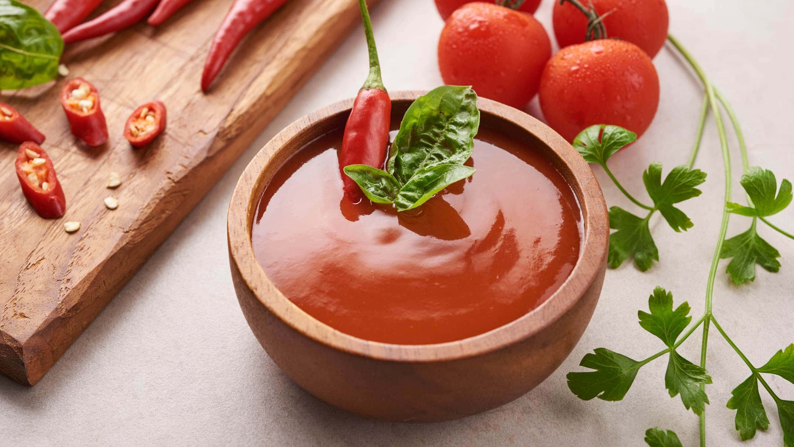 Red Sauce 桌布 壁紙 — 一個木碗裝滿濃郁的紅色番茄醬，飾以羅勒和辣椒，周圍環繞著新鮮食材。