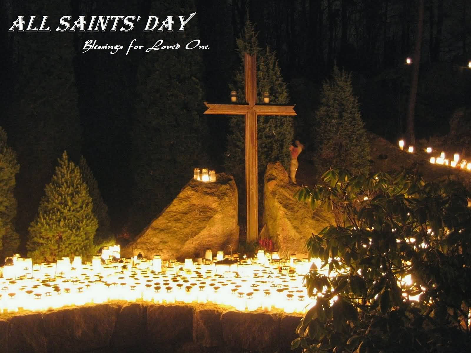 All Saints Day 桌布 壁紙 — 一個木製十字架在夜晚莊嚴地矗立，周圍有數百支發光的蠟燭在森林空地中。