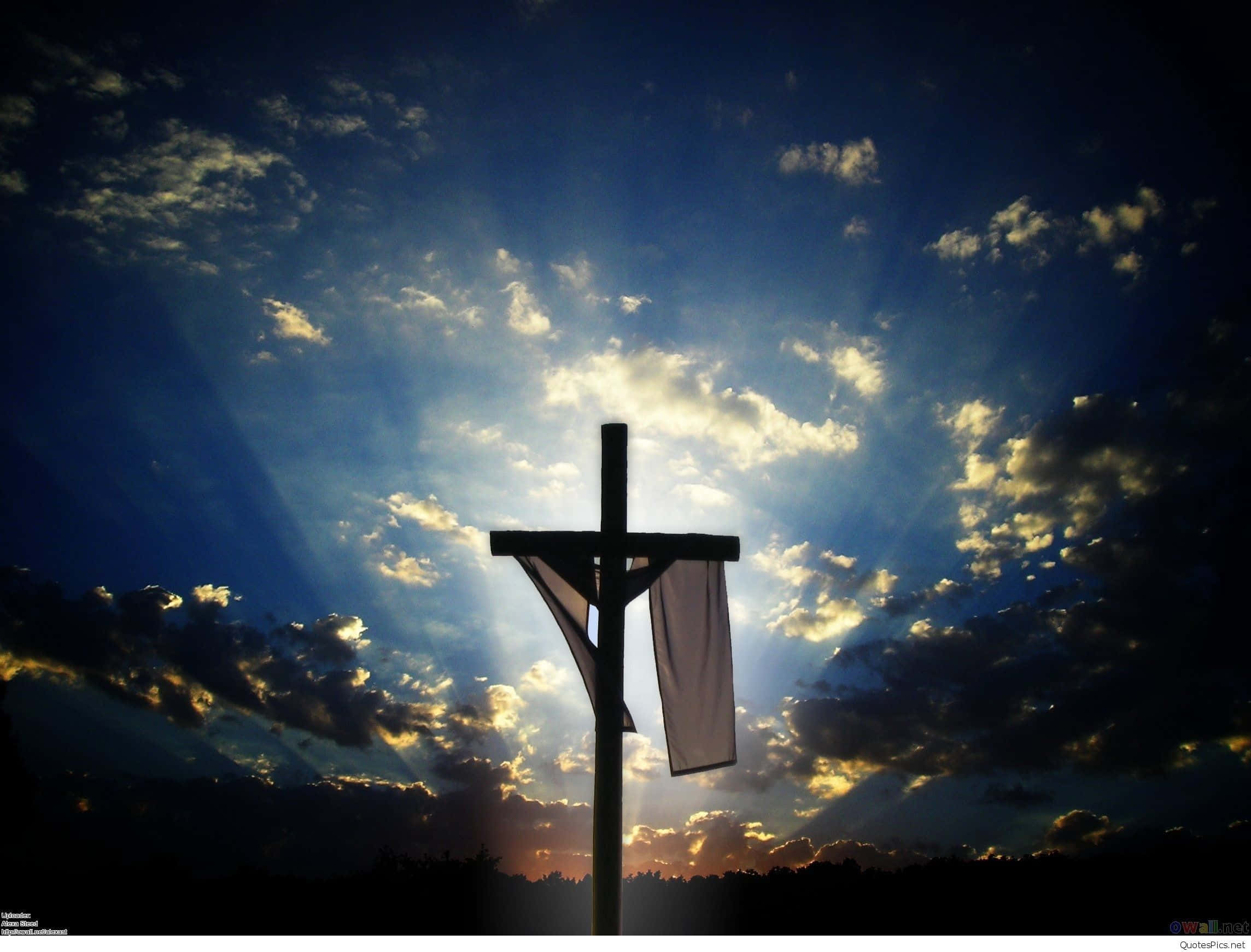 Jesus iPhone 桌布 壁紙 — 一個木製十字架在日落時分剪影在戲劇性的天空下，燦爛的陽光穿透金色雲層。
