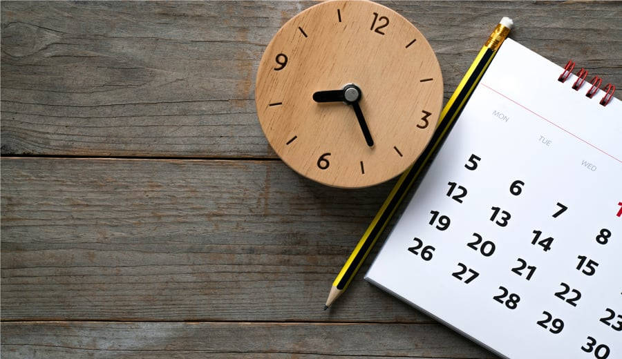 timer 桌布 壁紙 — 一個木製時鐘、鉛筆和日曆放在風化的灰色木質表面上，暗示時間管理和規劃。