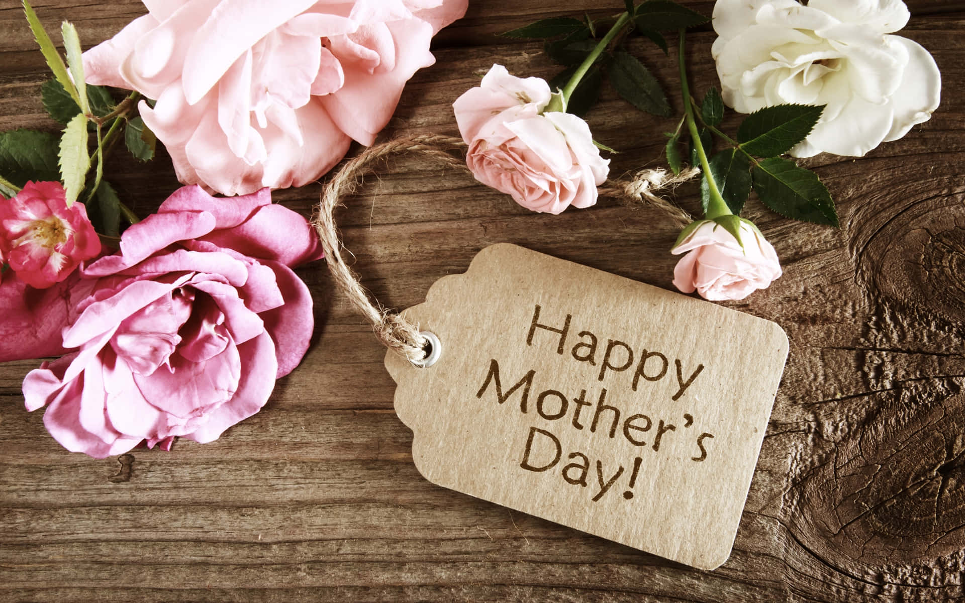 Happy Mothers Day 桌布 壁紙 — 一個木製標籤寫著「Happy Mother's Day」，用麻繩綁在粉紅和白色玫瑰之間，置於鄉村風格的木質表面上。