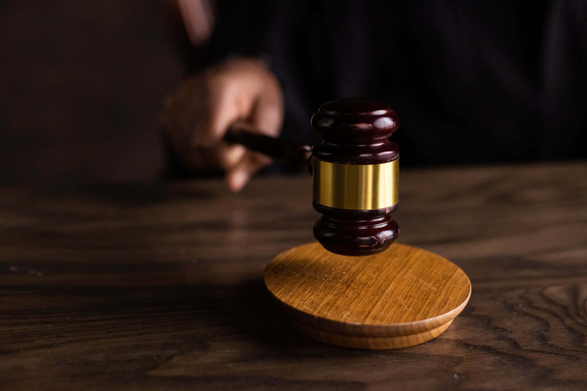 Gavel 桌布 壁紙 — 一個木製法官槌的特寫，帶有金色環，放在深色木桌上的木製音塊上。