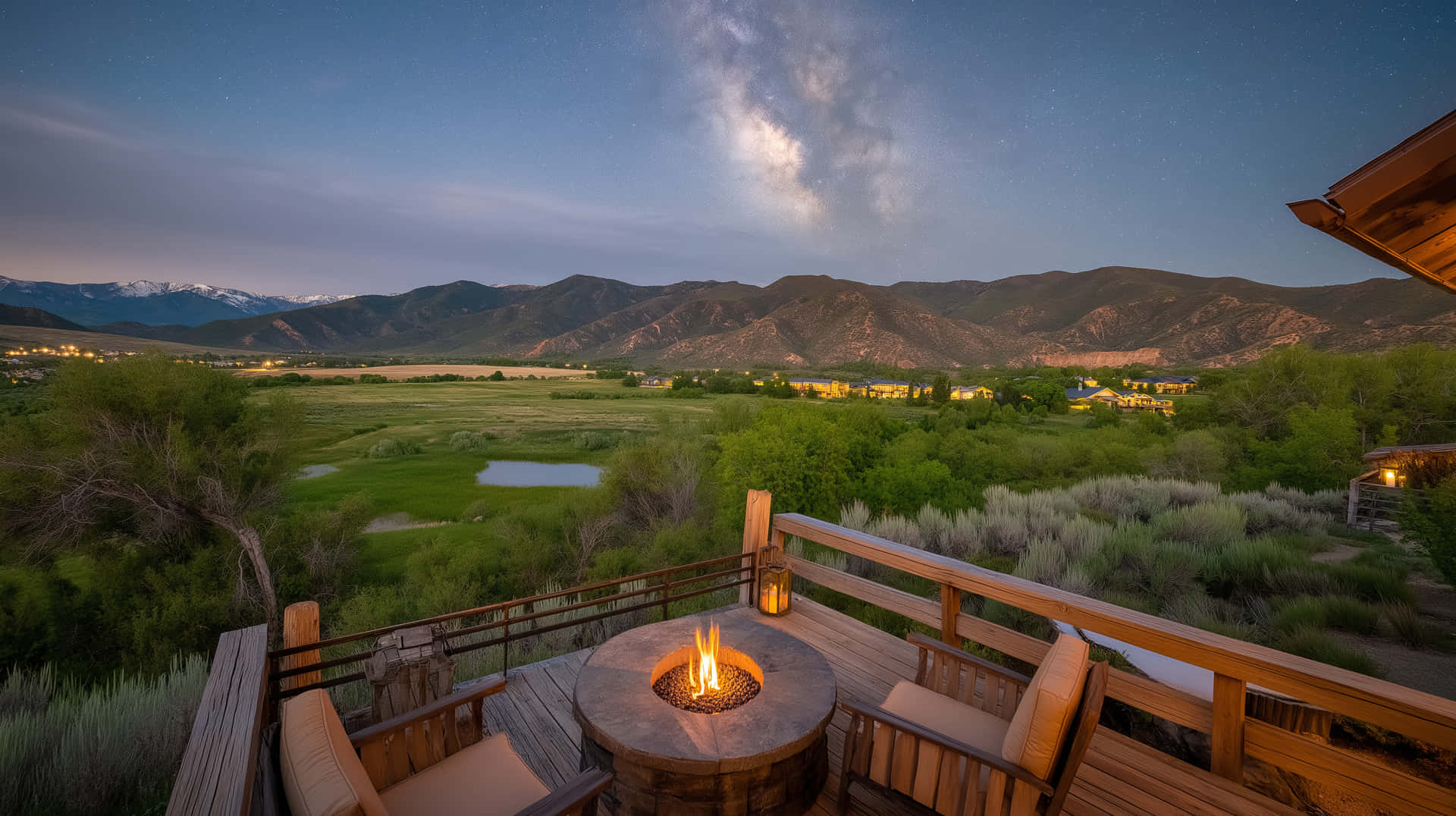 Cozy Outdoor Fire Pit with Mountain Valley View at Dusk 壁紙 — 一個木製甲板配有一個發光的火坑，俯瞰星空和遠處的雪山。