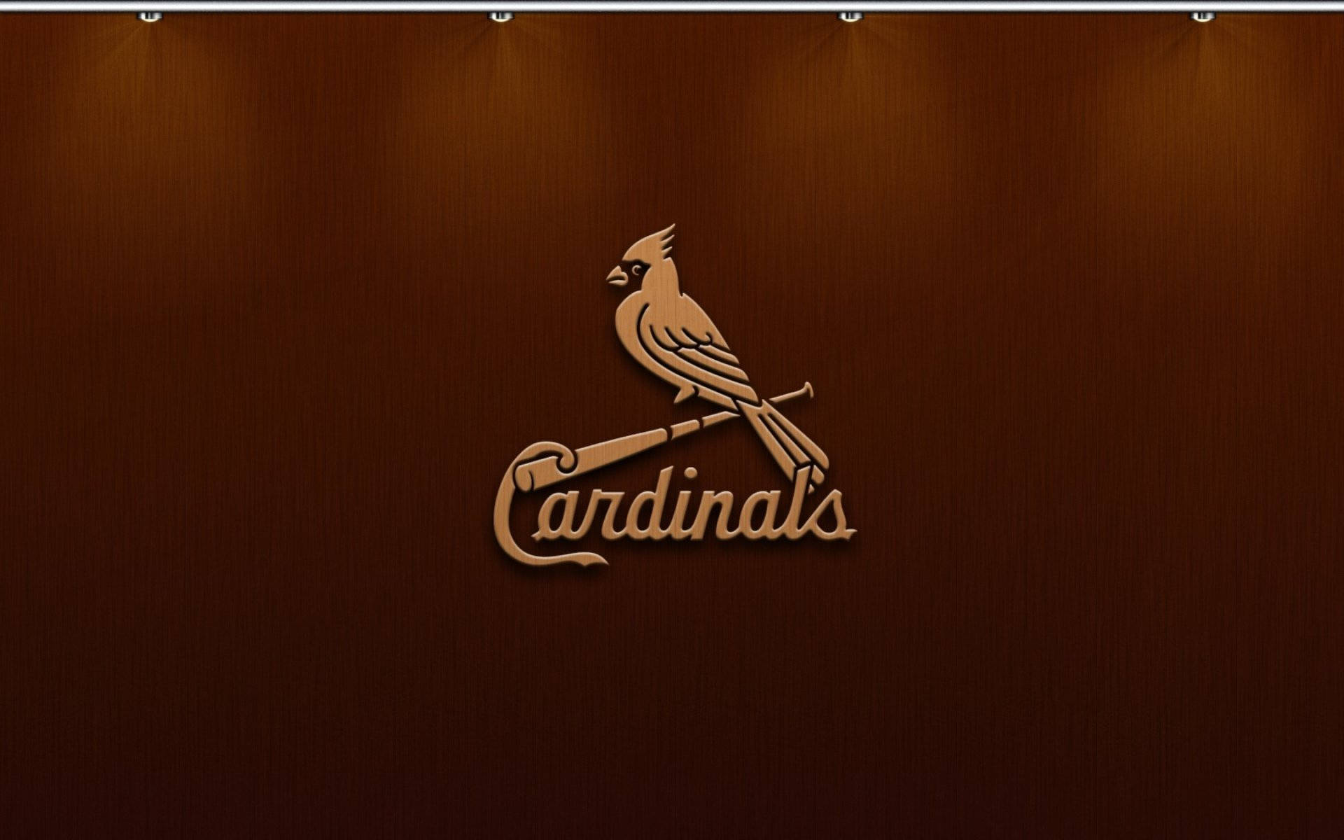 Cardinals 桌布 壁紙 — 一個木製的紅雀隊標誌，上面有一隻紅雀棲息在球棒上，被聚光燈照亮在濃郁的棕色木鑲板牆上。