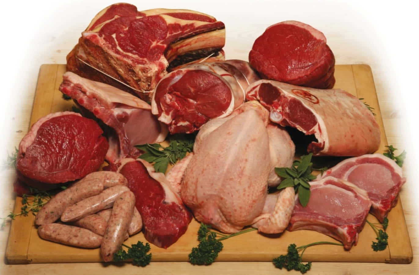 meat 桌布 壁紙 — 一個木製砧板上展示著豐富的生肉拼盤，包括牛排、肋骨、香腸和家禽，並以新鮮歐芹裝飾。