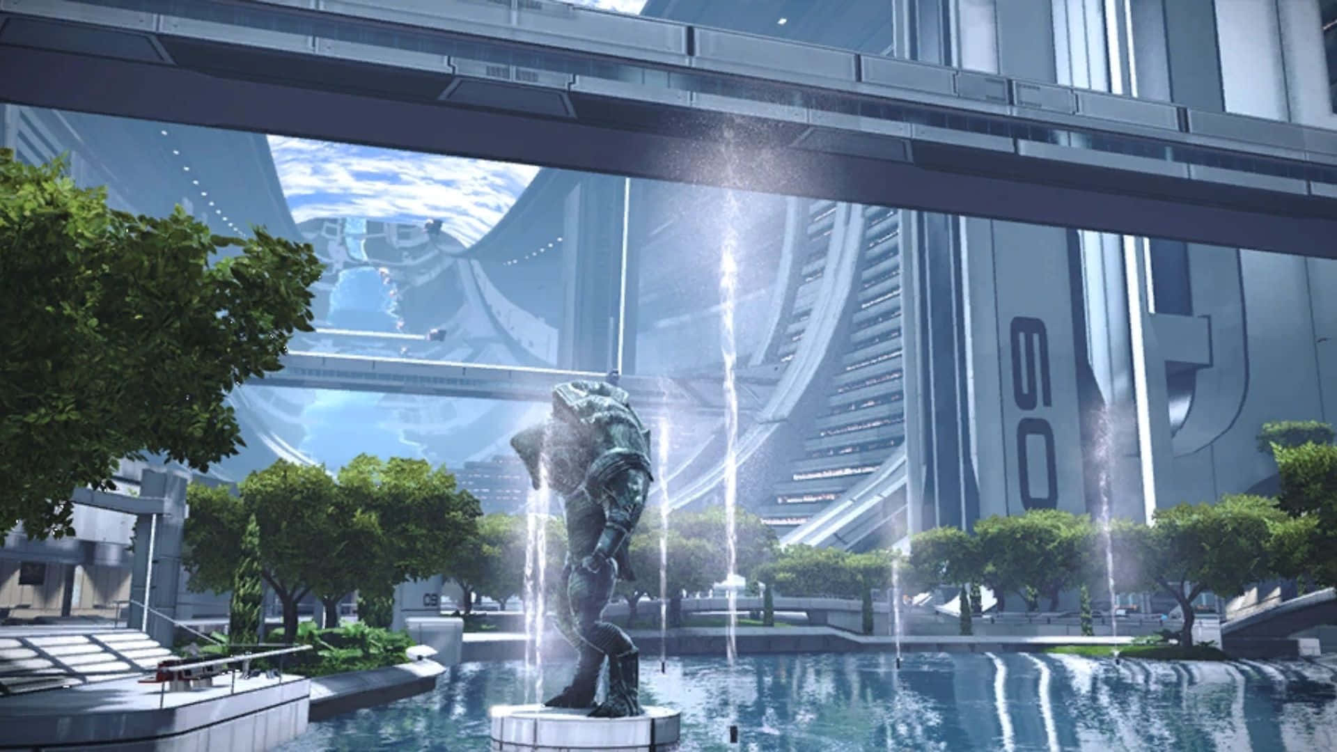Mass Effect Citadel 桌布 壁紙 — 一個未來主義的城市廣場，有一座青銅雕像，描繪一個蹲伏的人物，周圍是噴泉和茂密的綠樹，天空明亮。