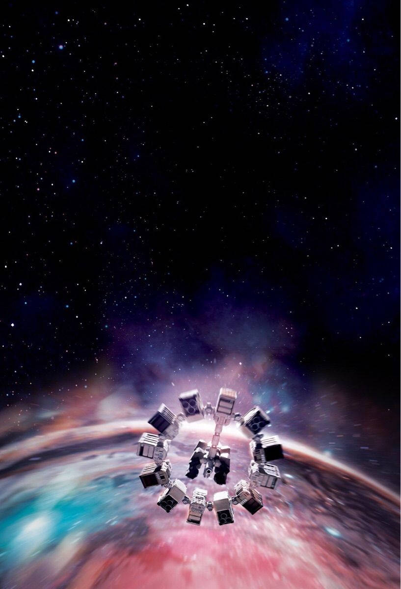 星際效應 桌布 壁紙 — 一個未來太空站圍繞著一個充滿活力的星雲運行，星雲中有旋轉的粉紅色、藍色和紫色雲彩，背景是星空。