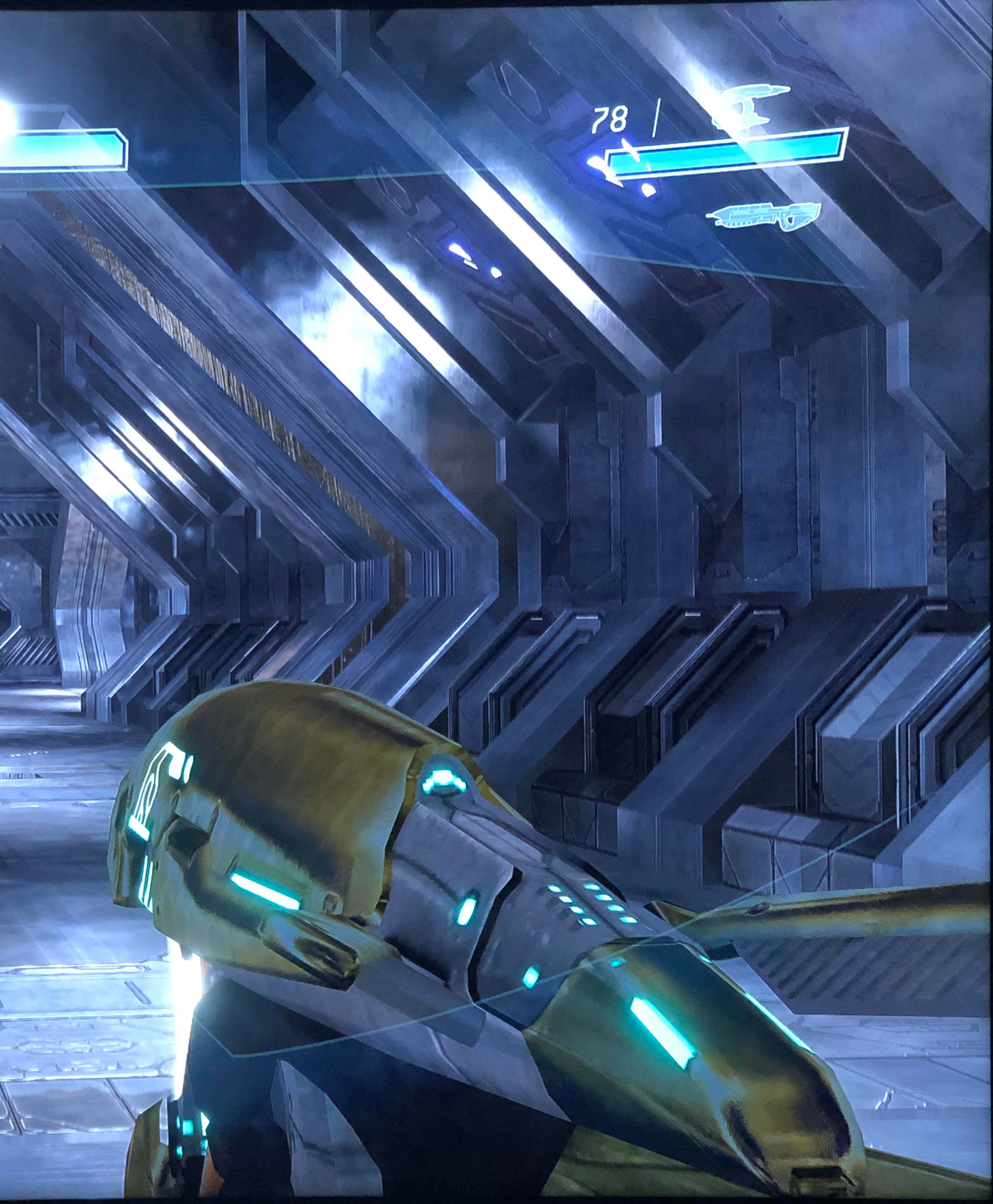 Plasma Rifle 桌布 壁紙 — 一個未來感的金色裝甲人物站在時尚的金屬走廊中，配有發光的藍色燈光和HUD元素。