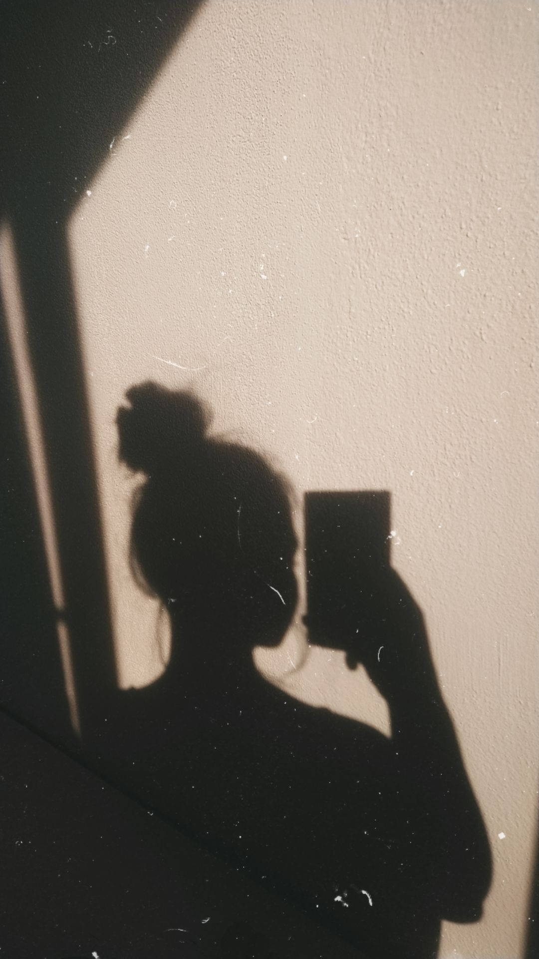 溫暖光線下，一個人手持電話在紋理牆上的影子。 — 美少女動態圖 壁紙